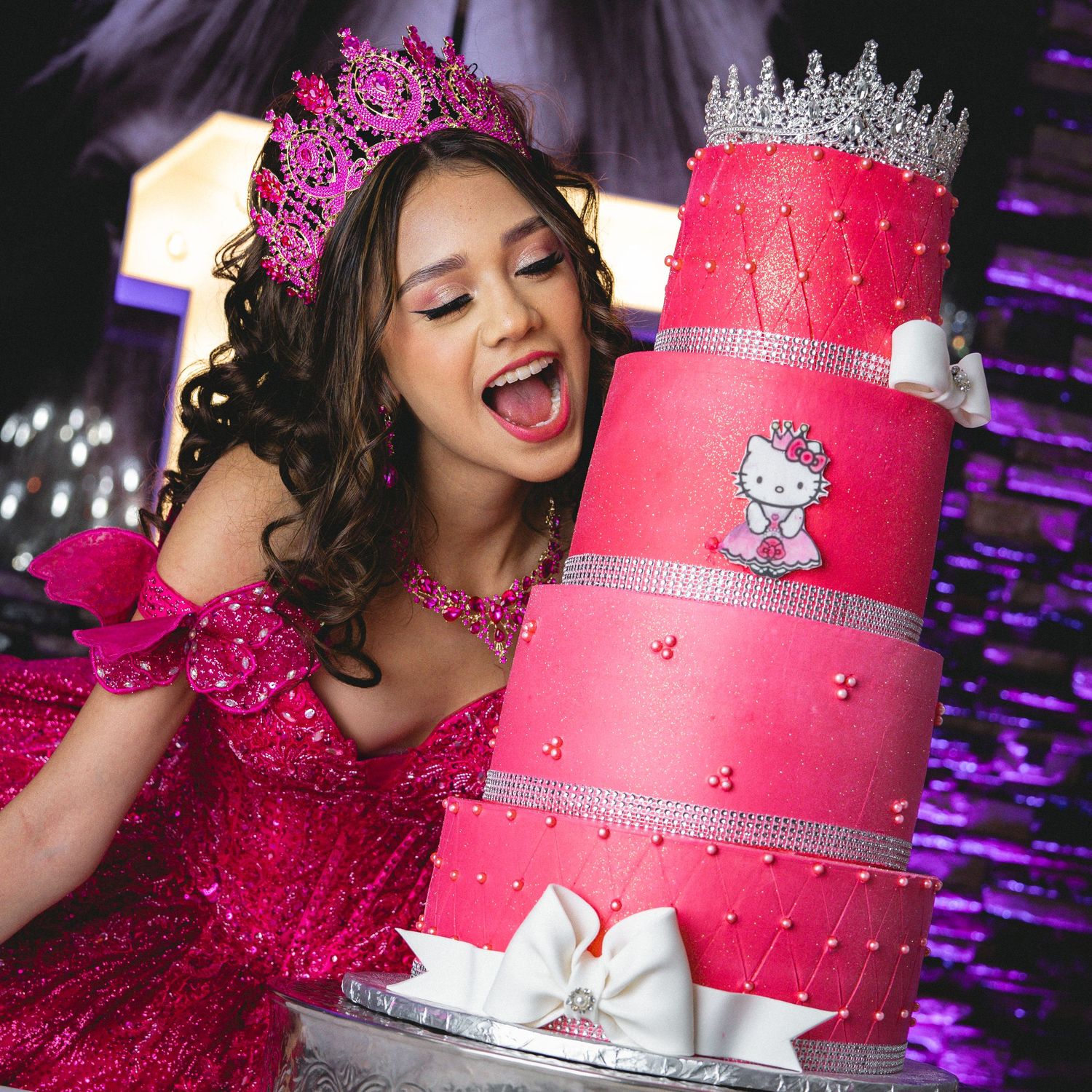 Bright pink quinceañera cake decorated with Hello Kitty and a sparkling tiara on top.