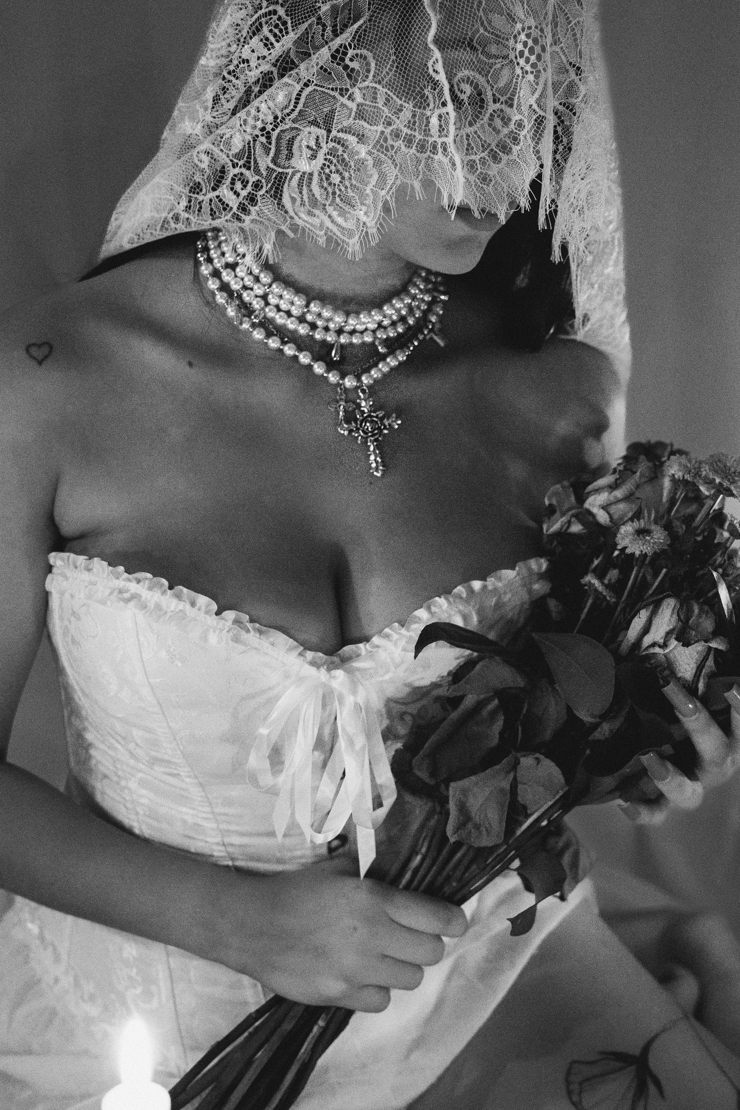 Elegant bridal portrait in black and white showing lace veil and pearl accessories.