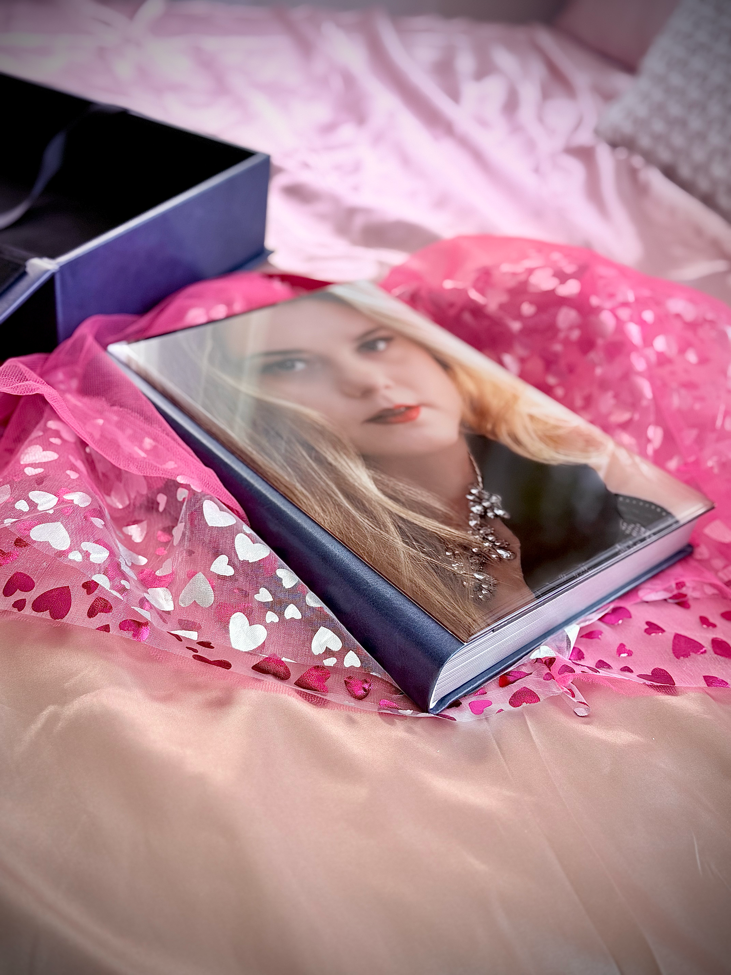 High quality photo print displayed in blue gift box with pink floral decorative paper and soft lighting.