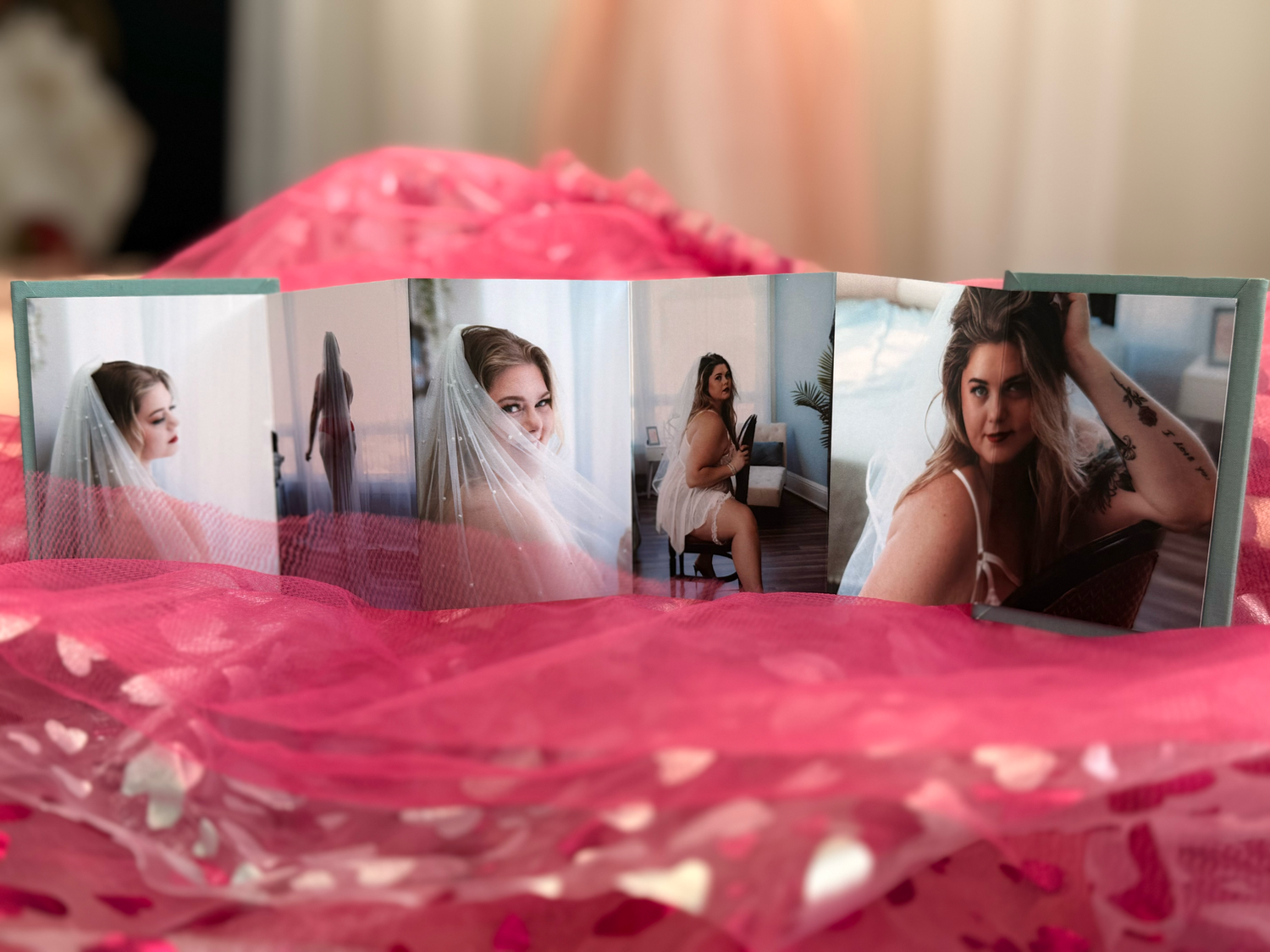 Wedding photo prints displayed on pink fabric showing bridal portraits and boudoir photography shots.