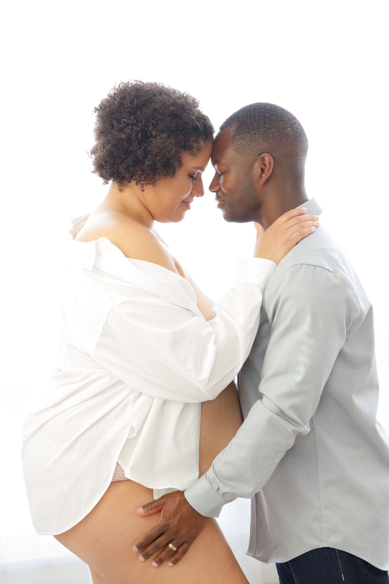 A black and white photo series showing an affectionate couple embracing in intimate poses against a light background.
