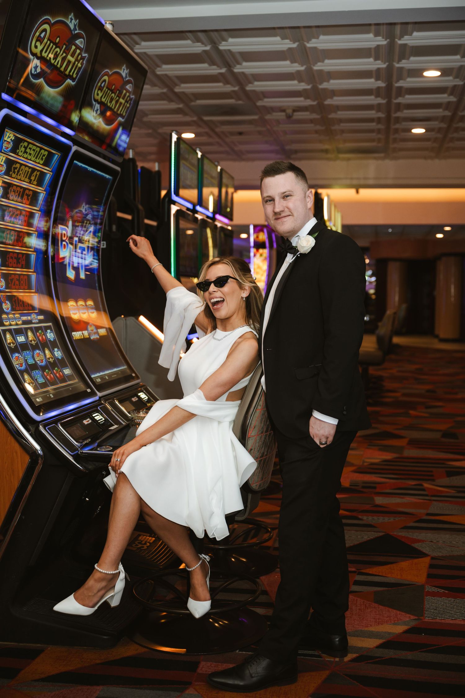 A playful wedding photo by slot machines in a Las Vegas casino.