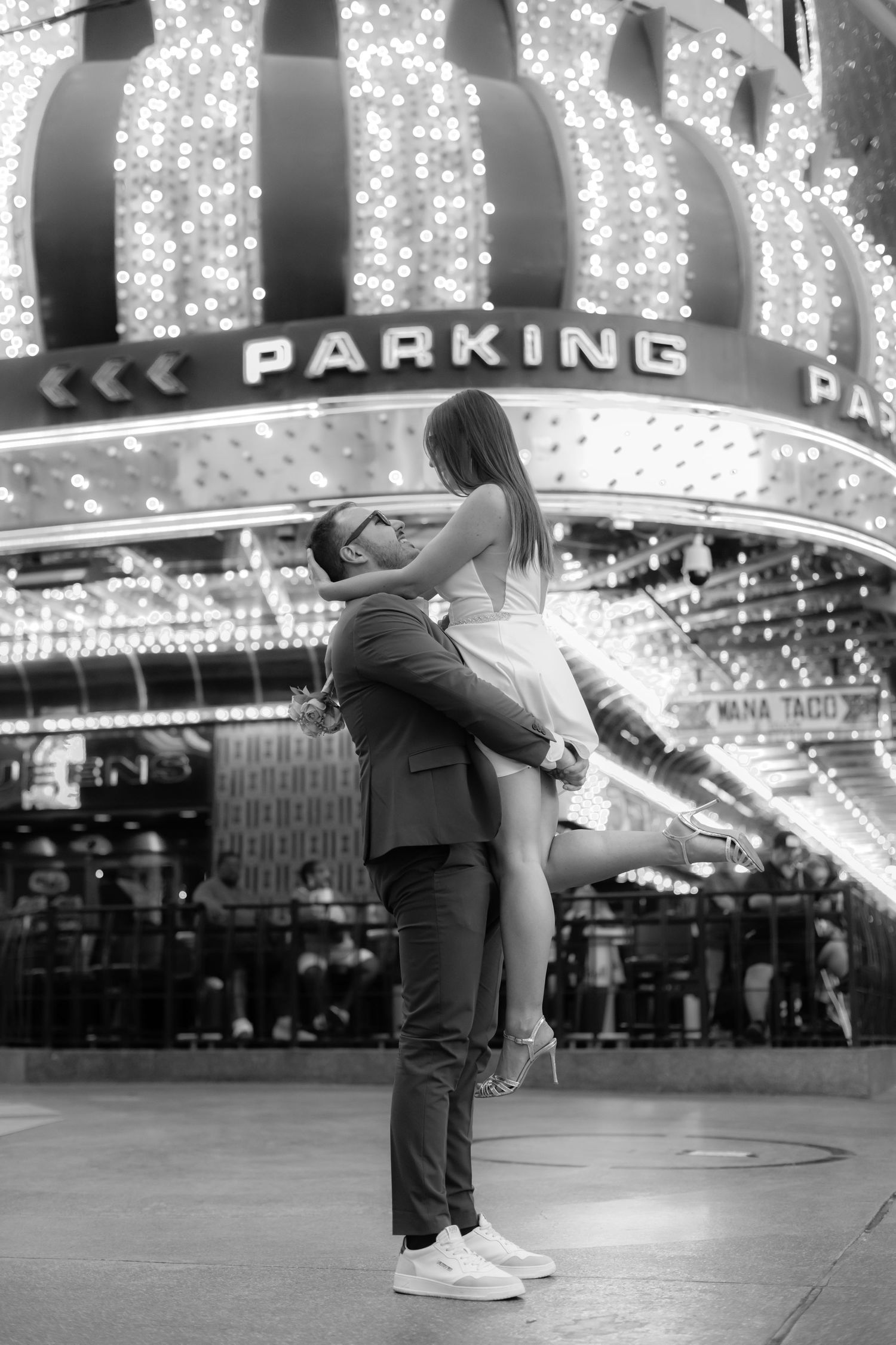 Couple dancing and twirling under vintage casino lights in Las Vegas.