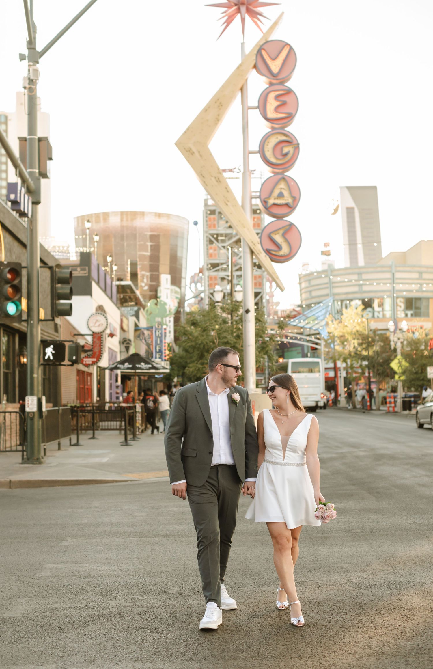A couple strolls down Fremont Street during golden hour in Las Vegas.