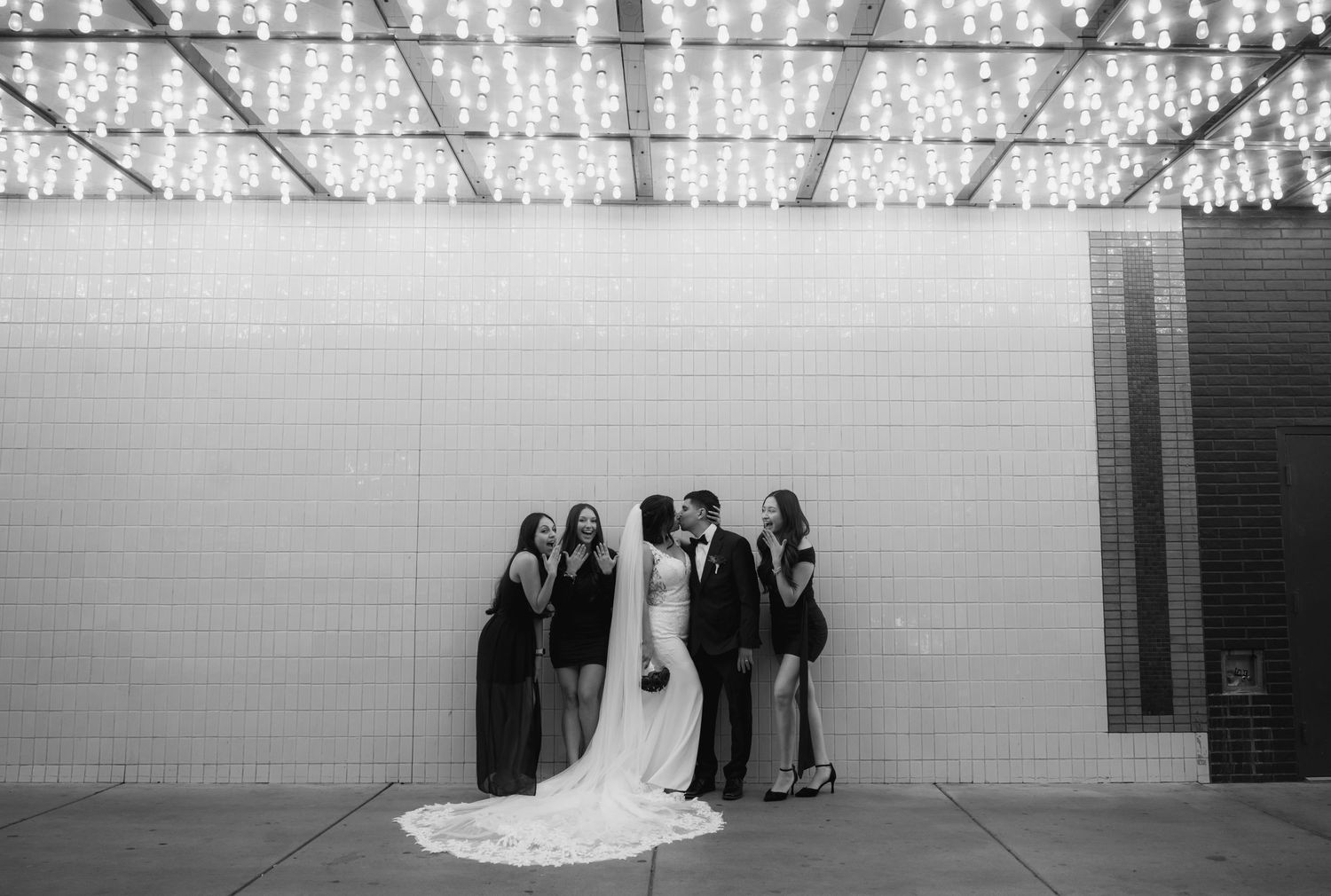 A series of black and white wedding photos showing a couple posing in front of a classic car.
