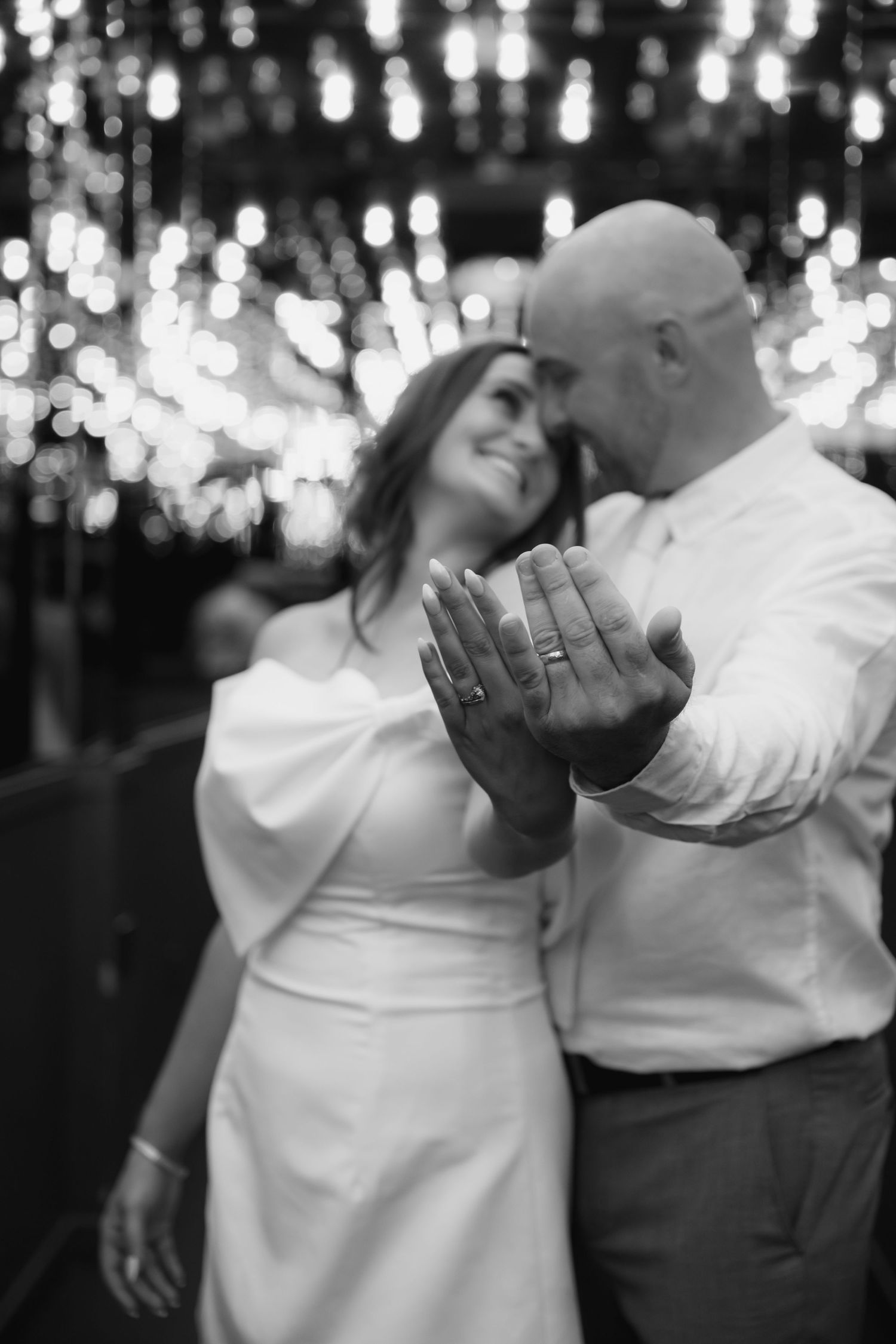 Romantic dance sequence under glittering lights in black and white.