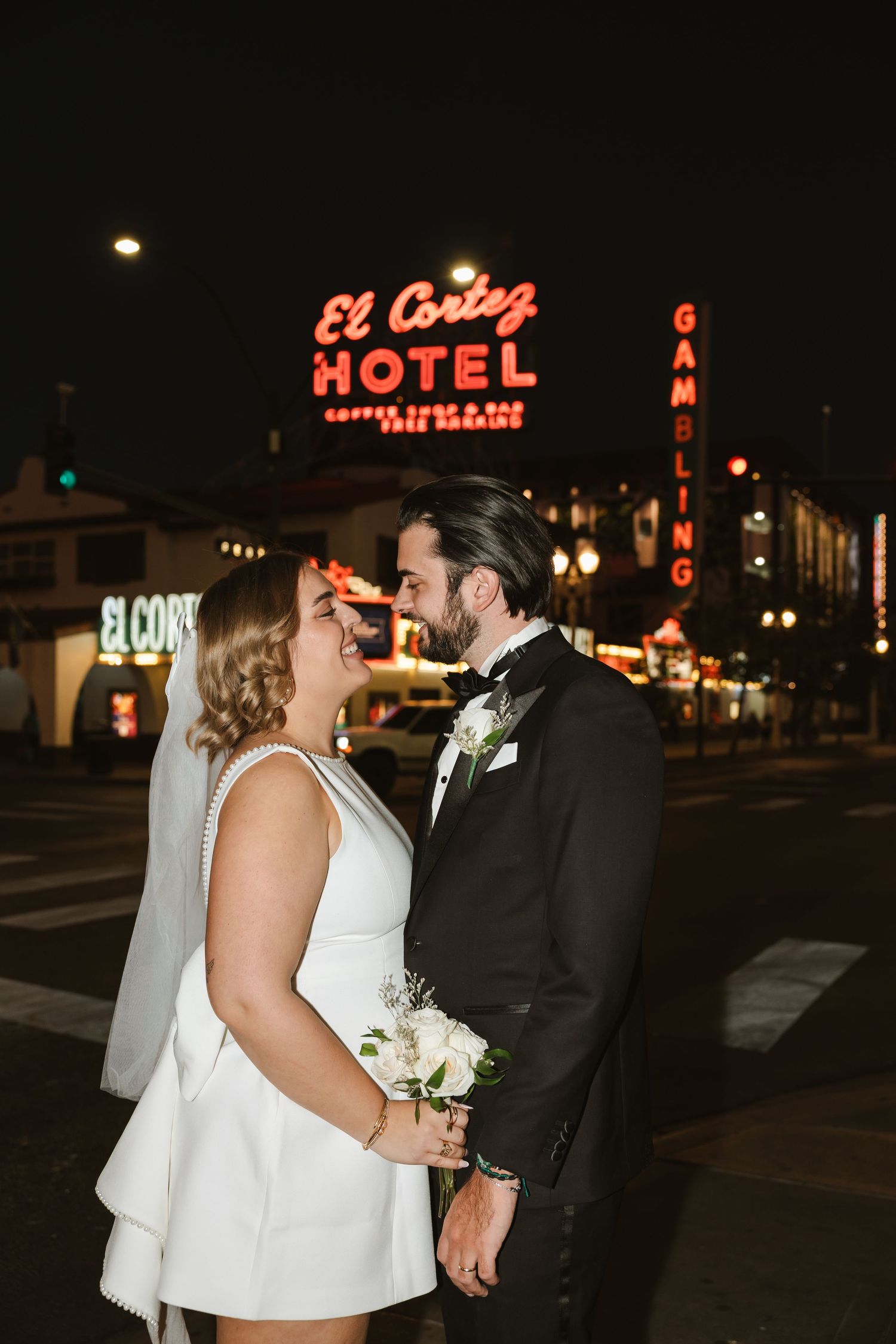 Romantic nighttime wedding photos with vintage neon hotel signs in the background.