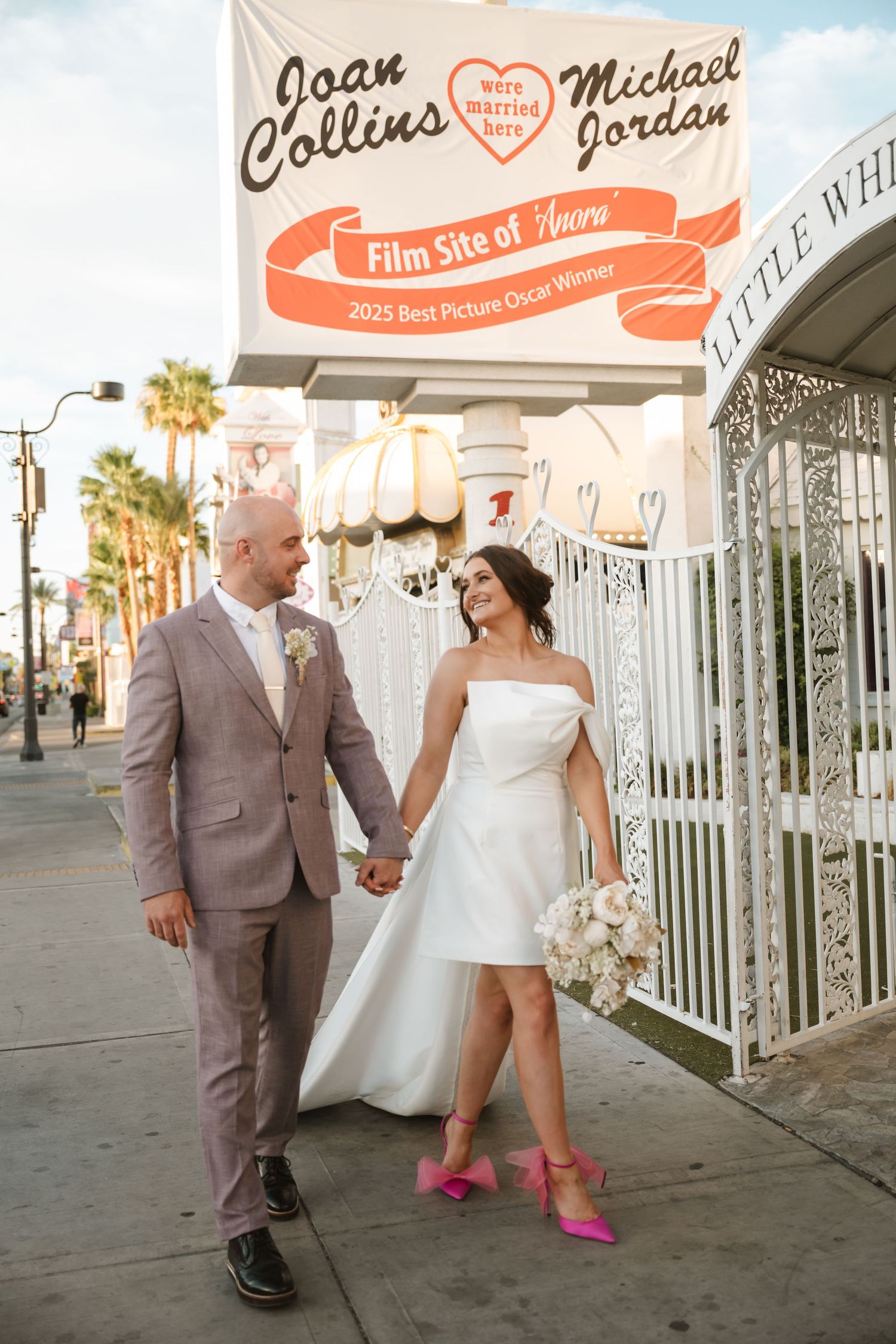 Wedding portraits outside a vintage Vegas chapel with the bride wearing bright pink shoes.