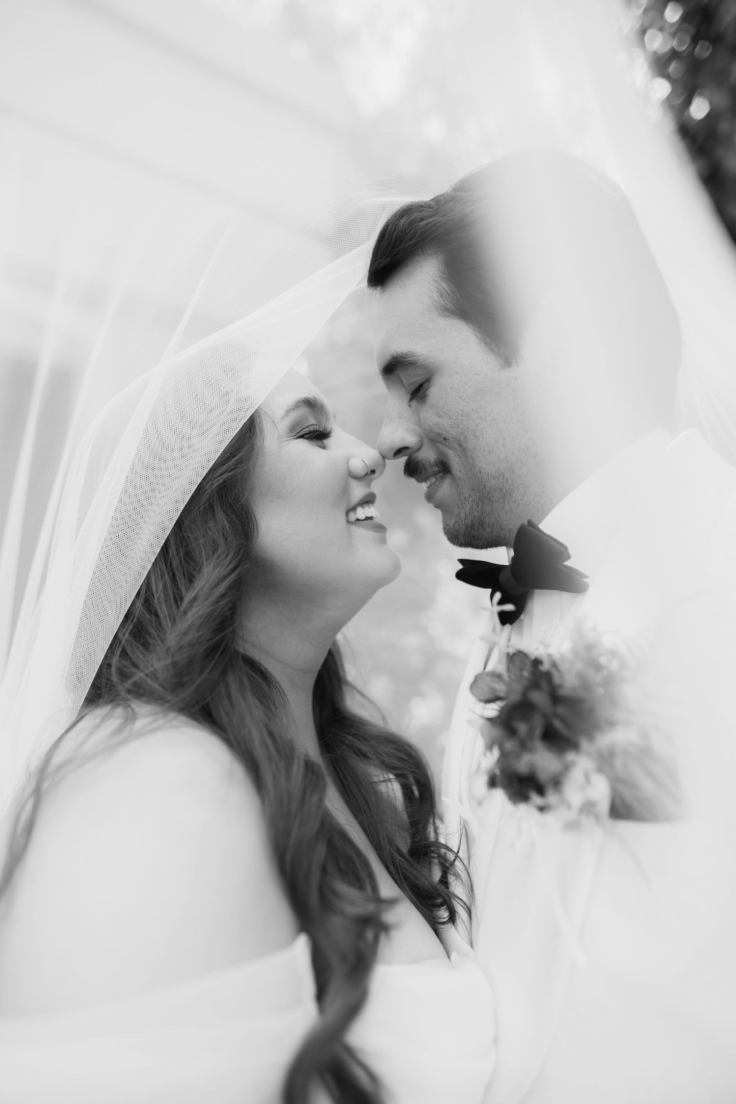A soft focus wedding portrait captured through a delicate veil.