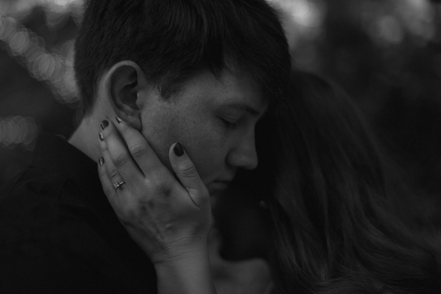 Artistic black and white close-up of couple's tender embrace.