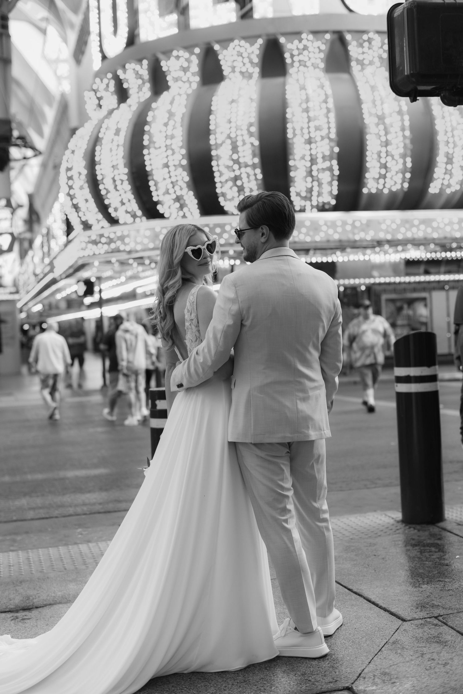 Romantic black and white series of a couple sitting together under twinkling lights.