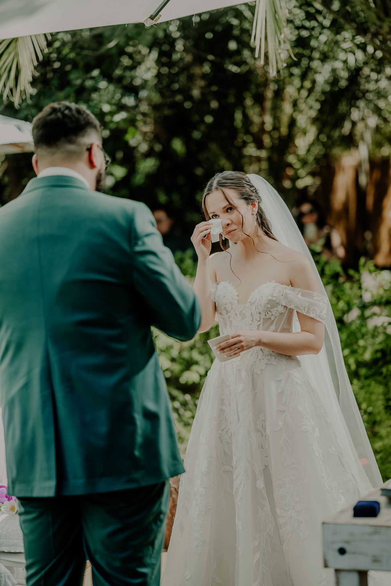 An emotional wedding ceremony moment in a lush garden setting under natural light.