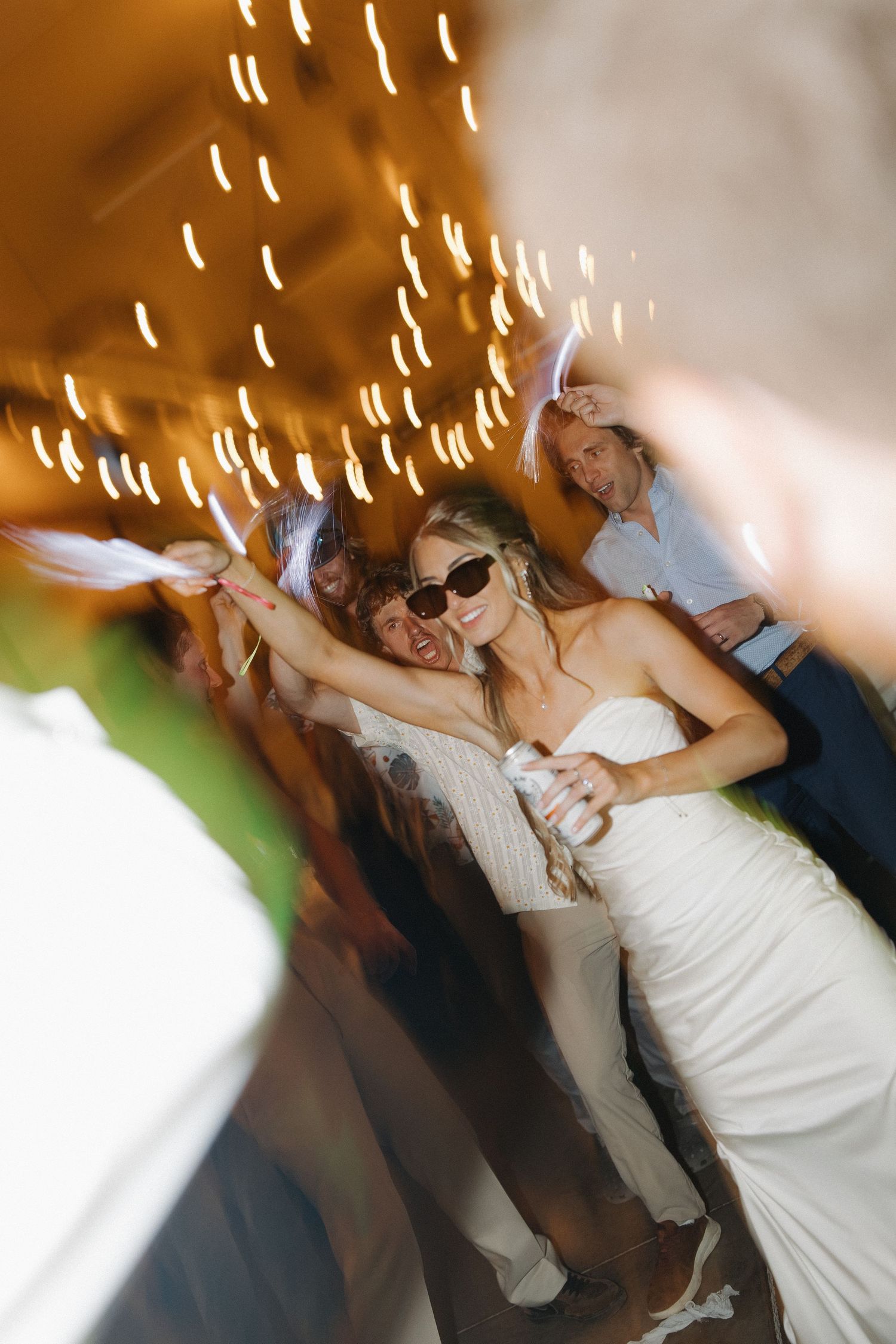 People dancing at a party with motion blur and twinkling lights creating a festive atmosphere on the dance floor.