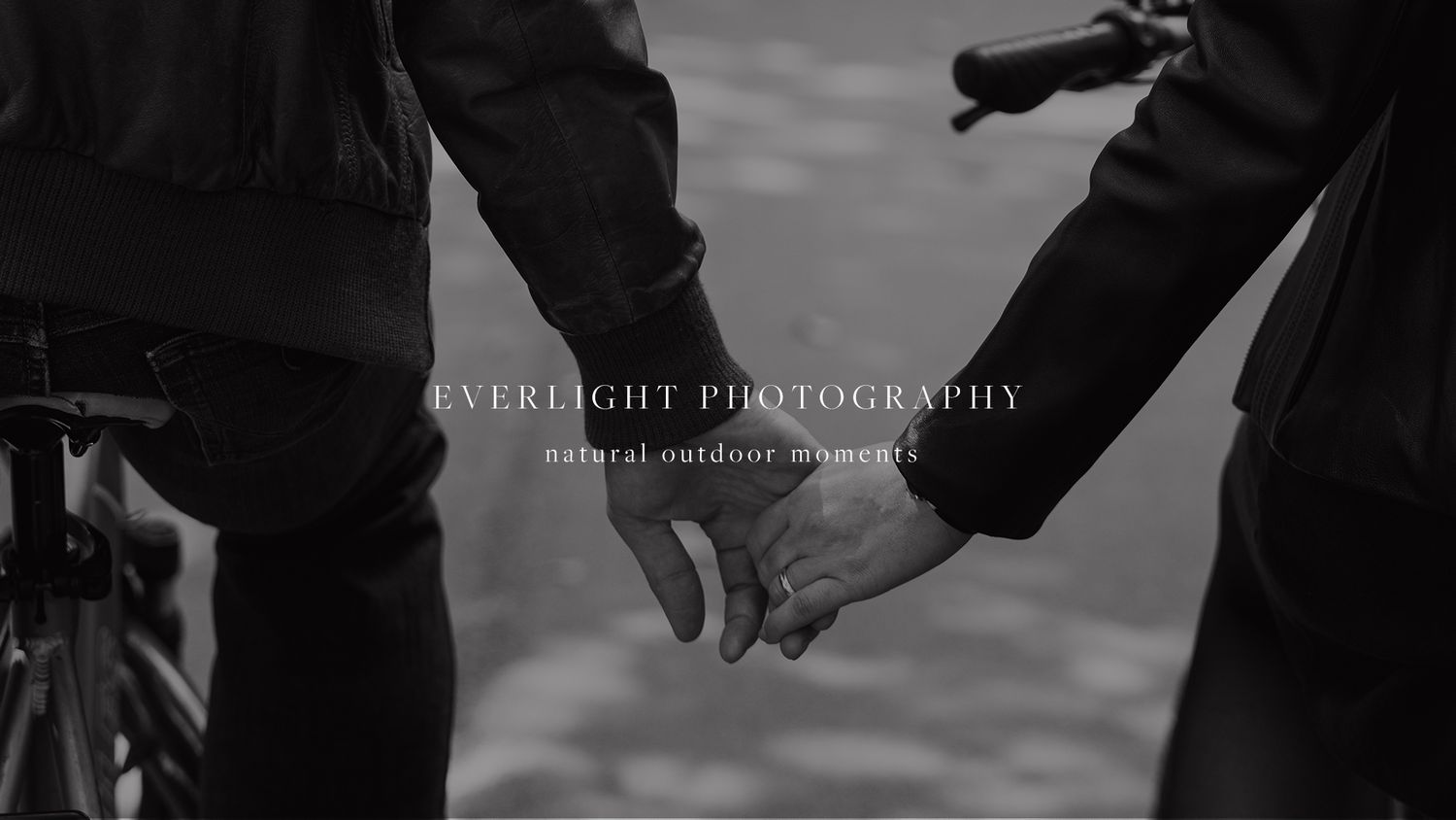 A black and white photo shows two people holding hands while walking together.
