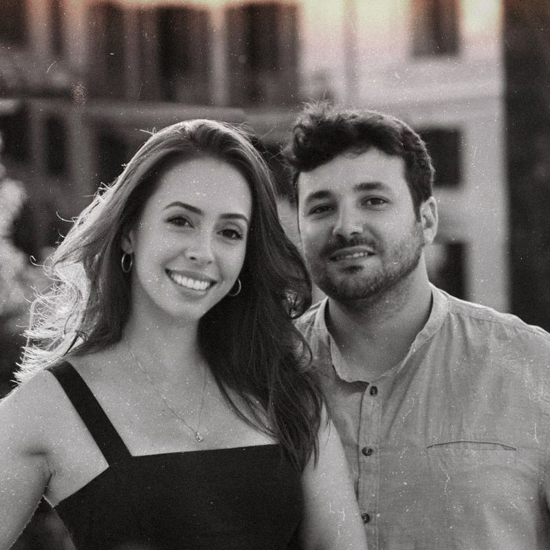 A warm black and white portrait of a couple in casual attire.