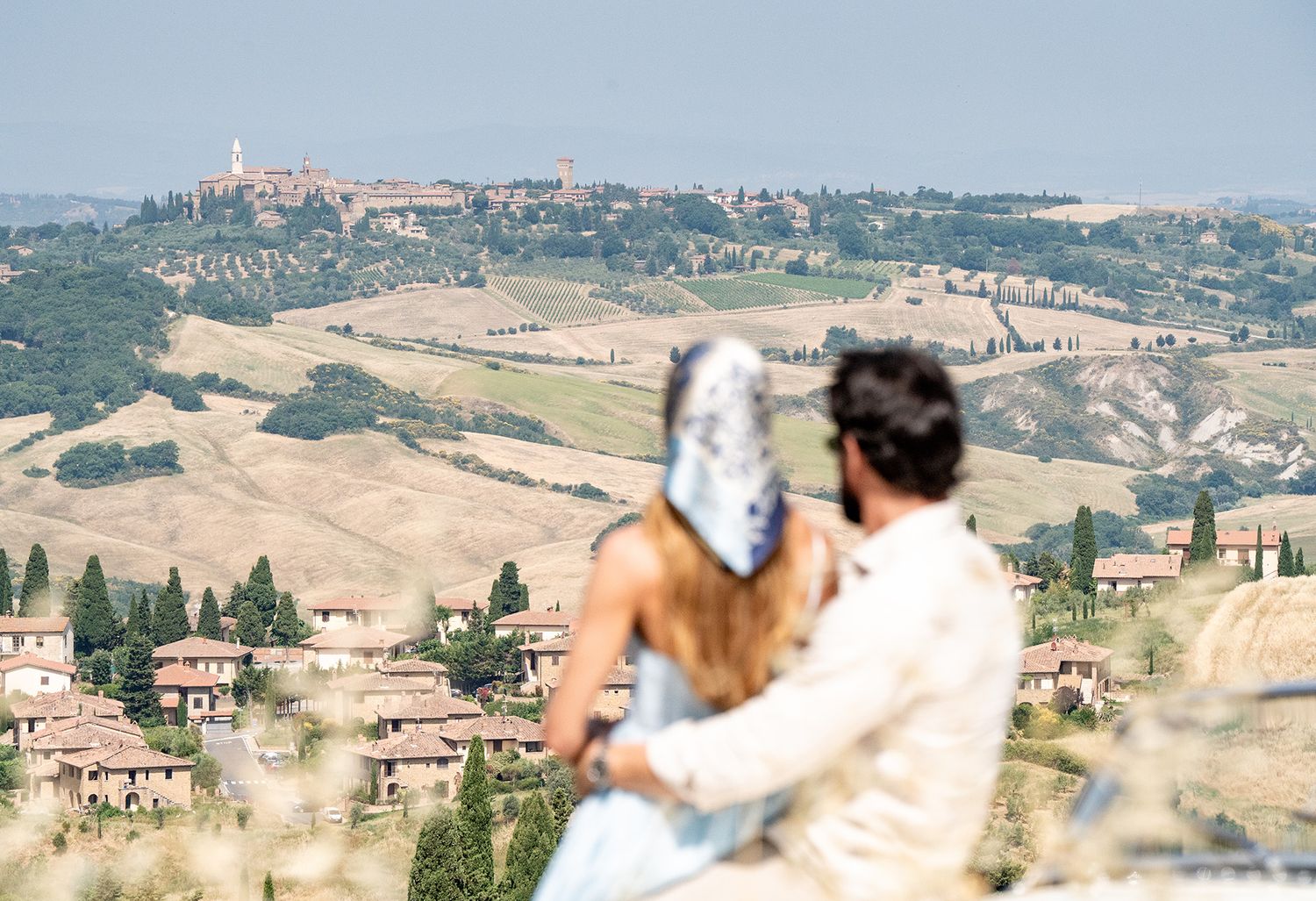 Rolling hills of Tuscany with traditional Italian villas and farmhouses dotting the scenic countryside landscape.