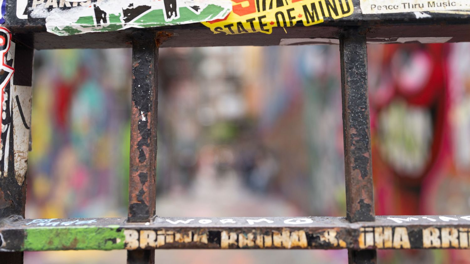 Colorful graffiti and street art covers a wall in an urban setting.