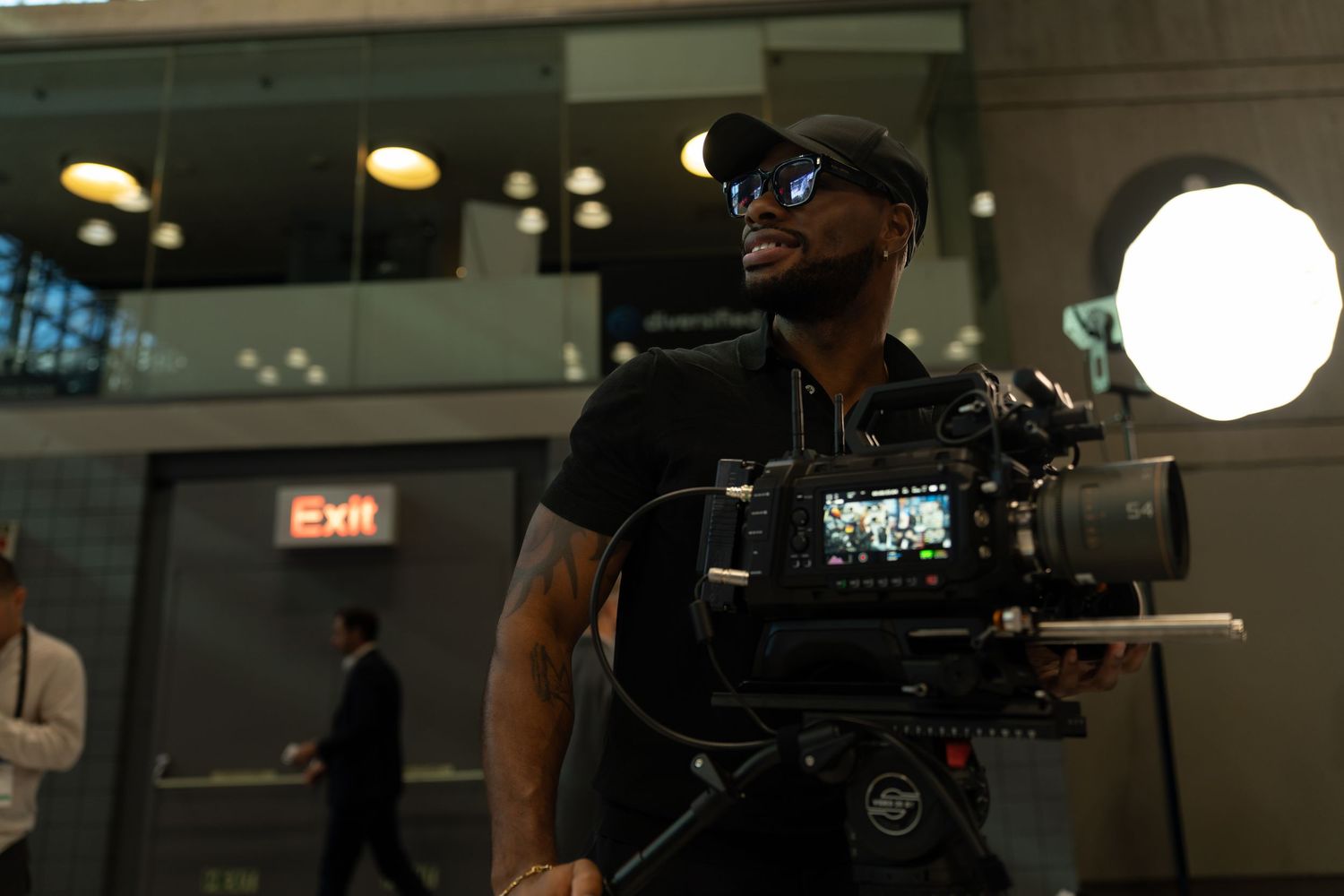 Film crew working with professional camera equipment in a dark indoor studio setting.