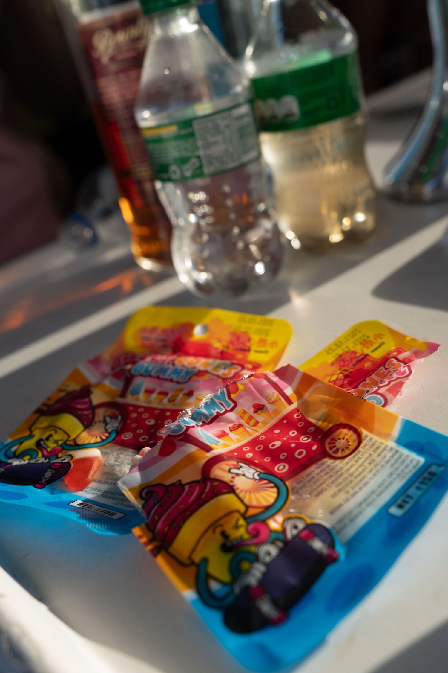 Colorful candy wrappers and snack packages arranged on a white surface.