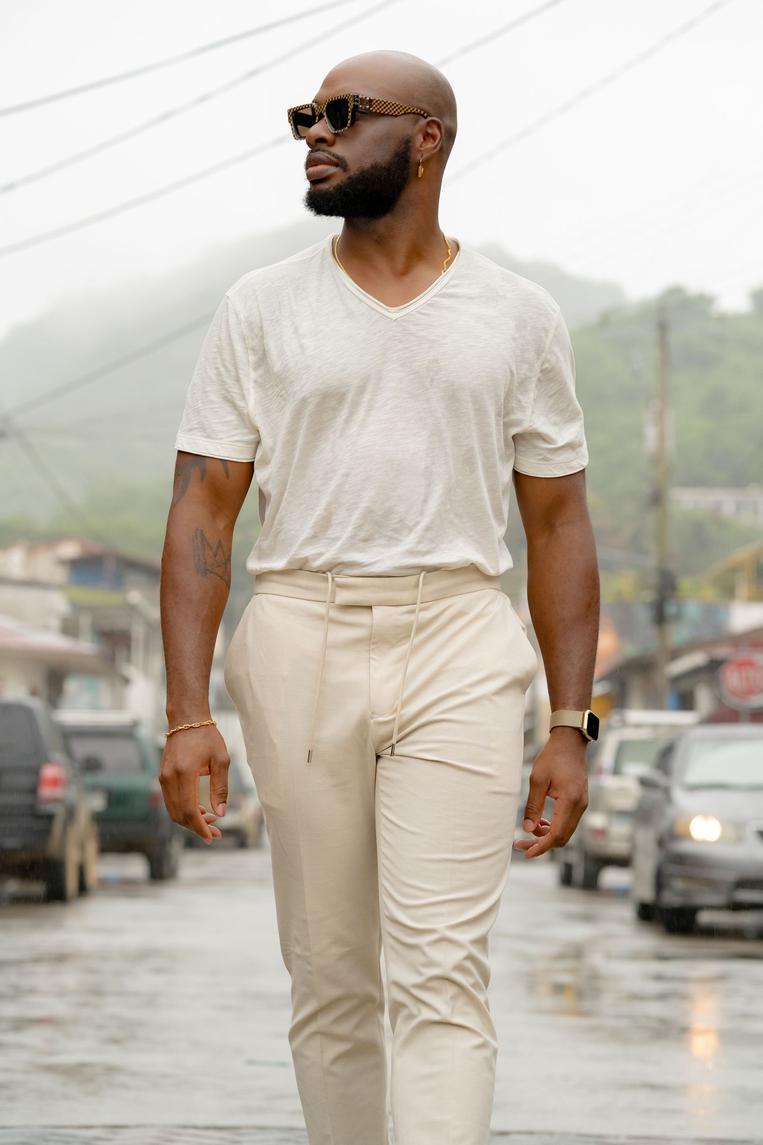 Stylish casual outfit featuring white t-shirt and beige pants on rainy street.