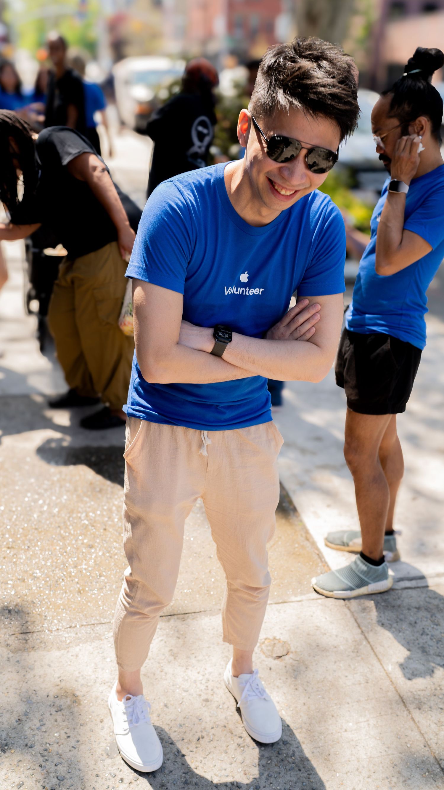 Staff members in blue uniforms and khaki pants standing together outdoors.