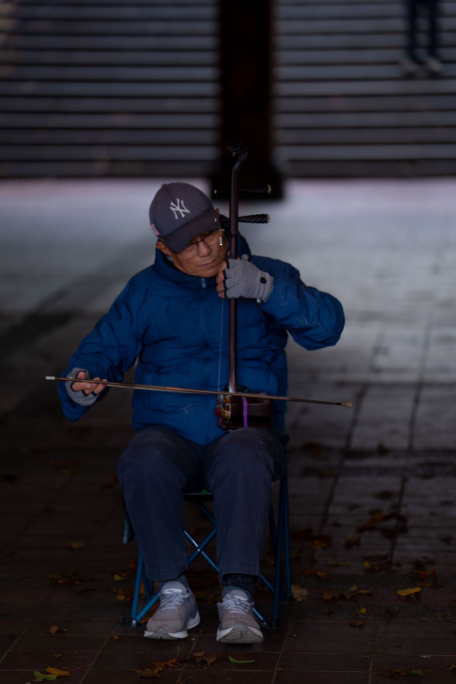 A sequence of photos showing someone in blue clothing performing a skateboarding trick in low light conditions.