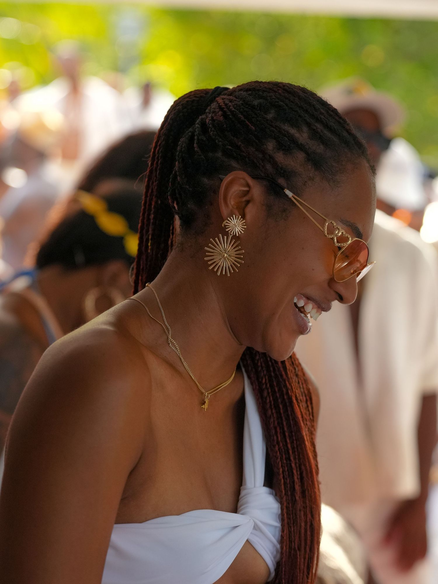 People mingling at an outdoor summer gathering wearing white and beige clothing with natural lighting.