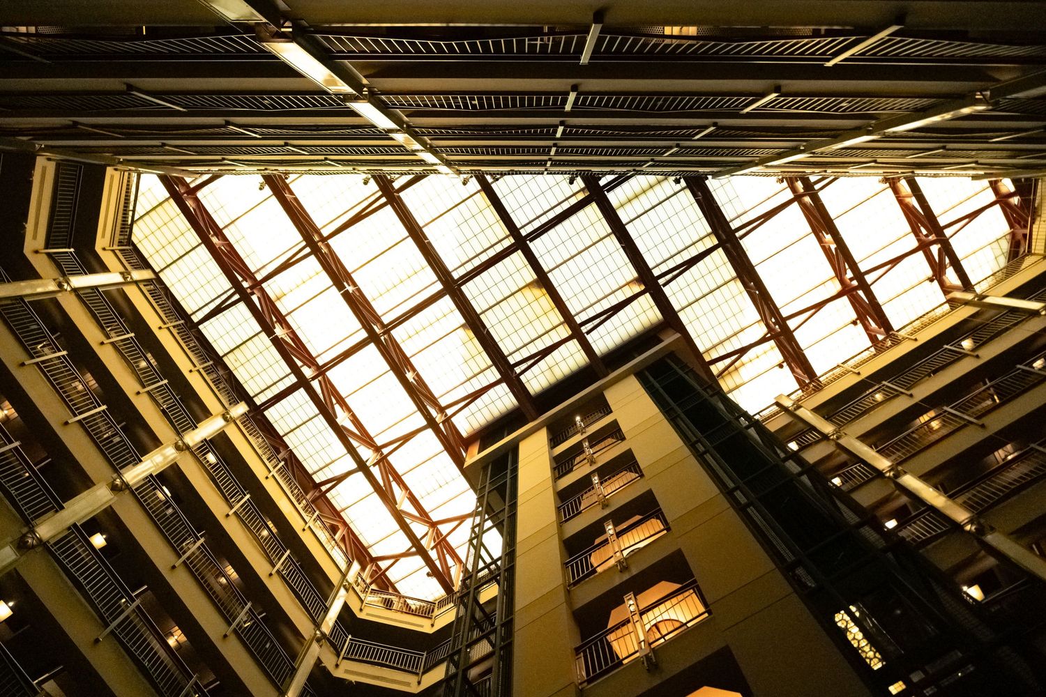 Dramatic upward view of illuminated industrial ceiling with geometric patterns.