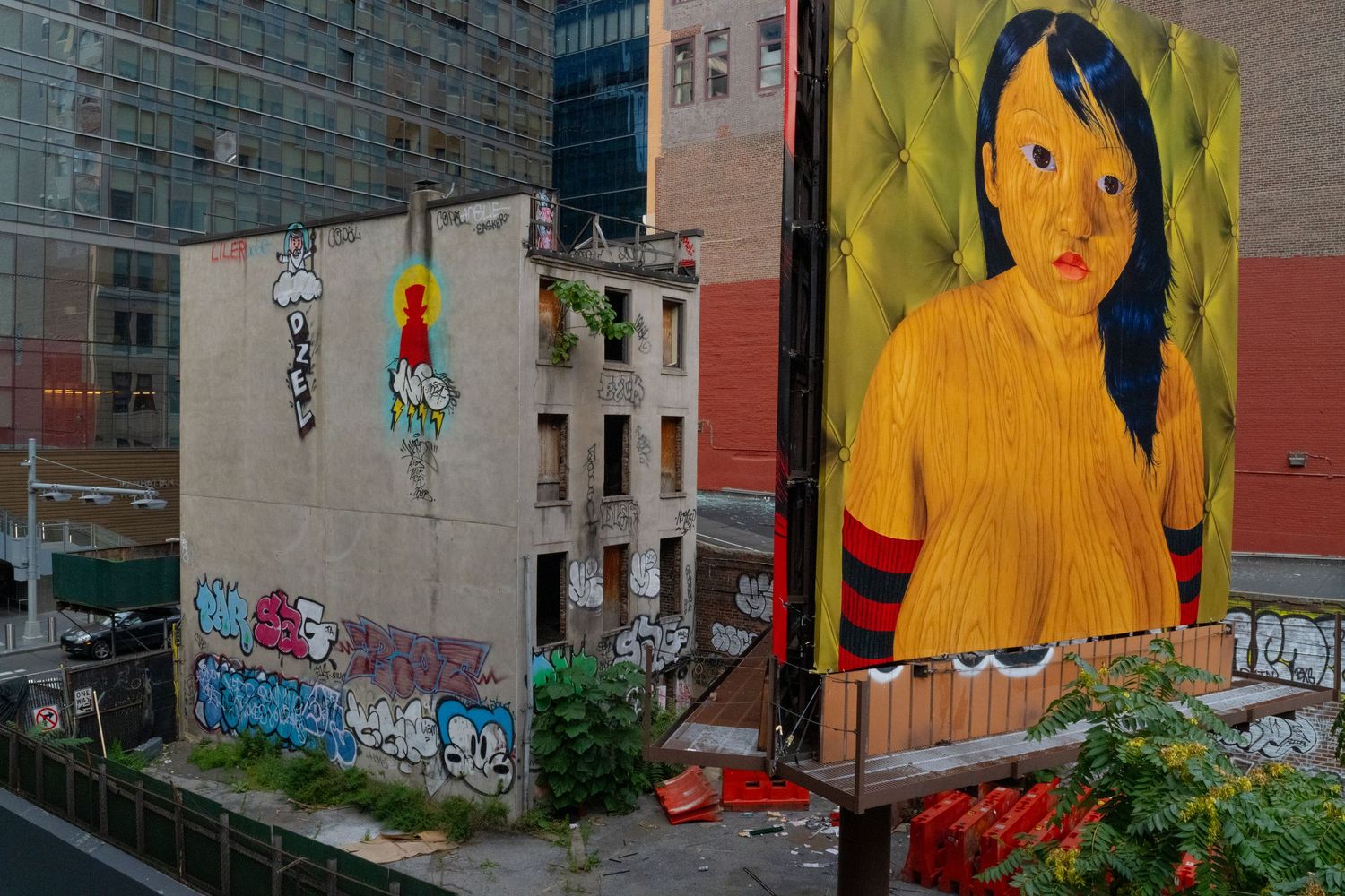Colorful street art murals featuring large yellow figures painted on urban buildings.