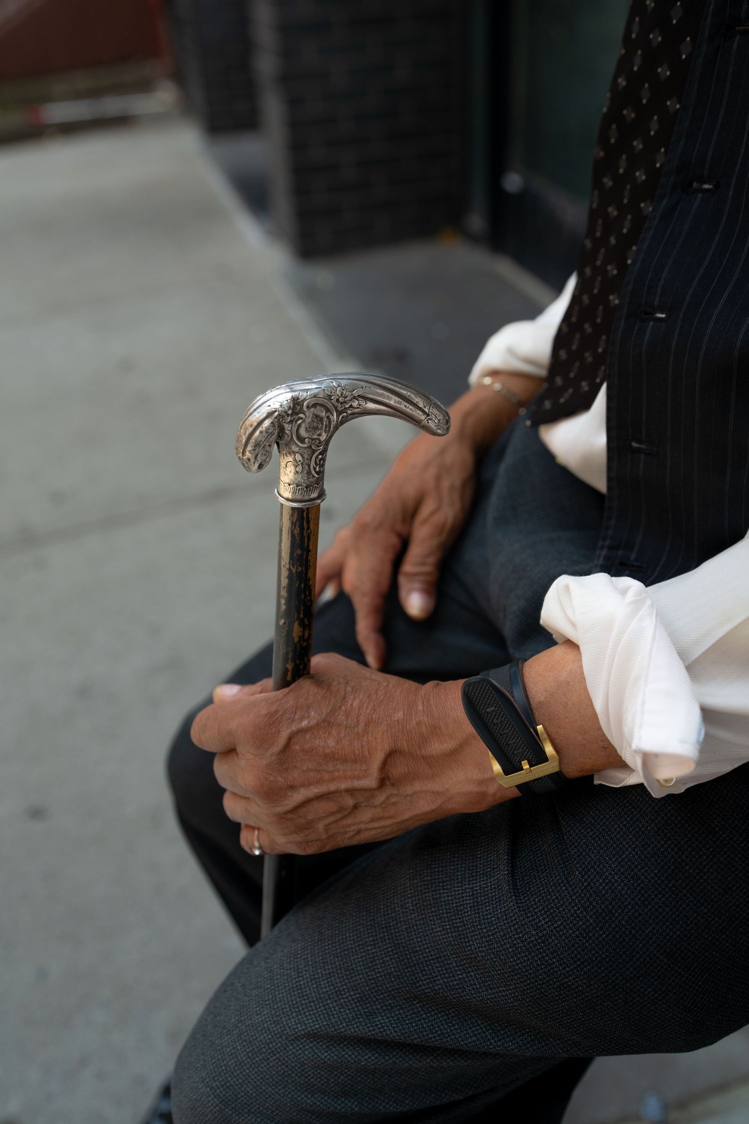 Multiple angles of hands holding a decorative walking cane.