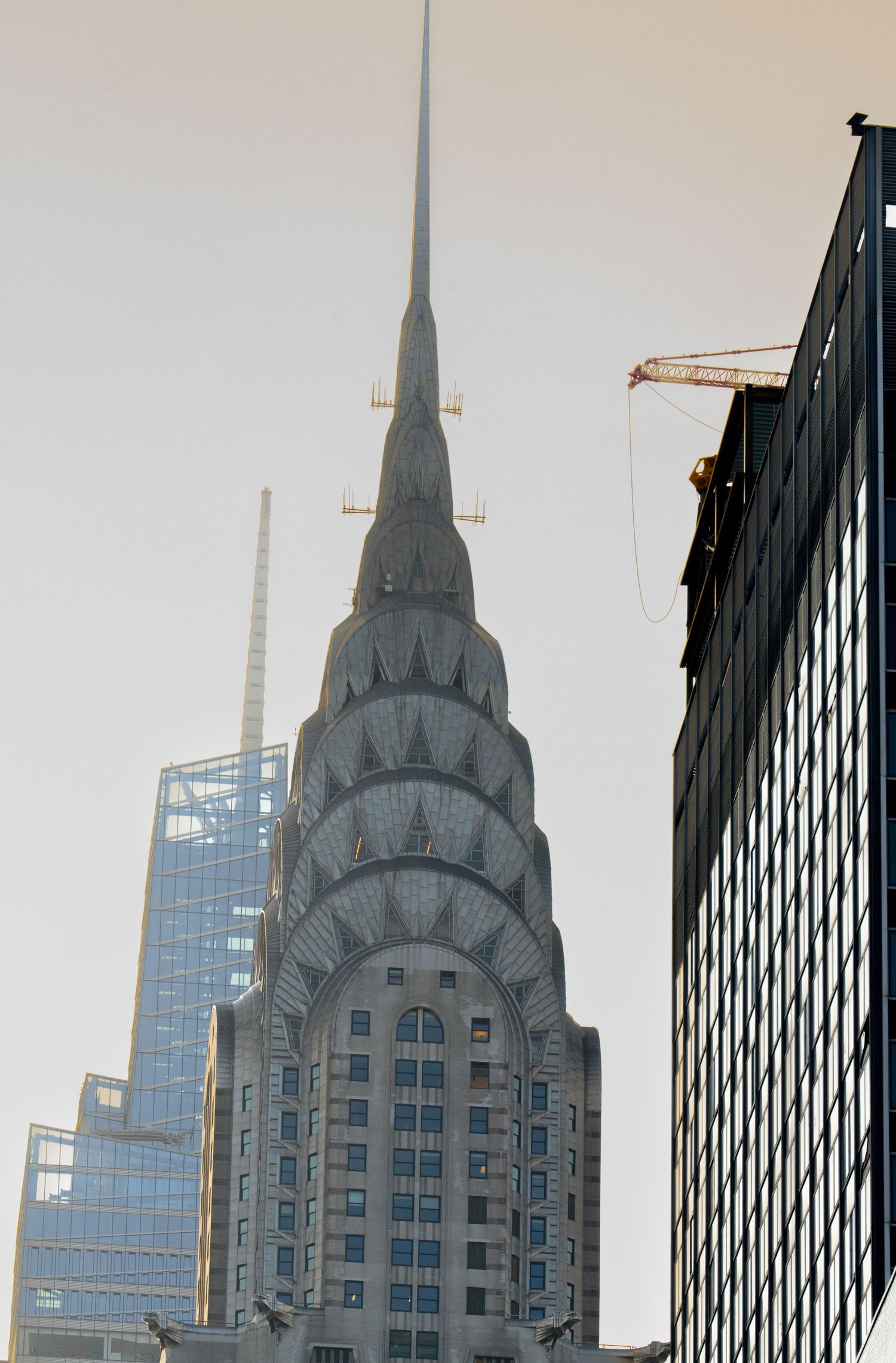 Close-up view of the iconic Chrysler Building spire in New York City against a cloudy sky.