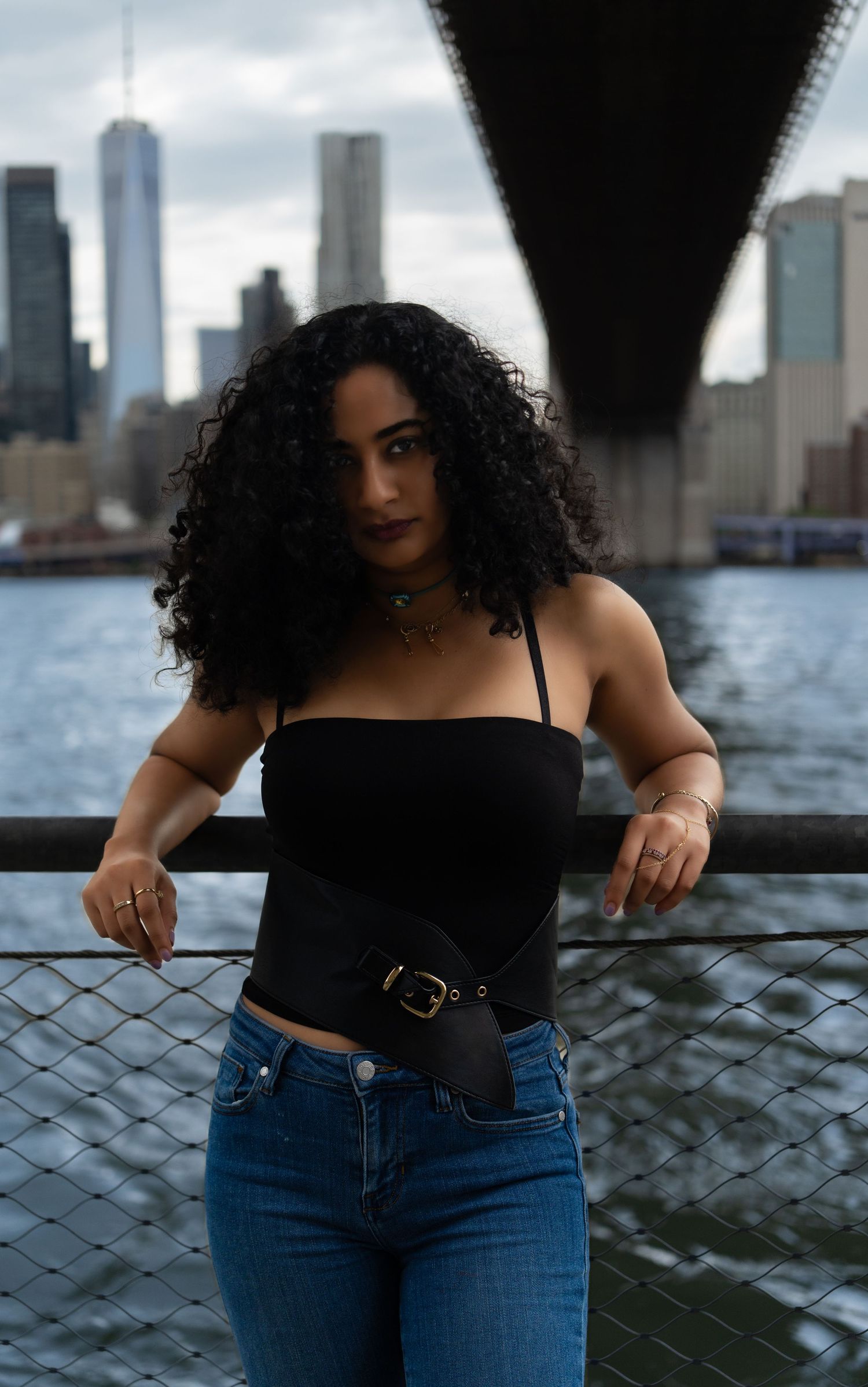 Urban portrait session with city skyline and waterfront in the background.