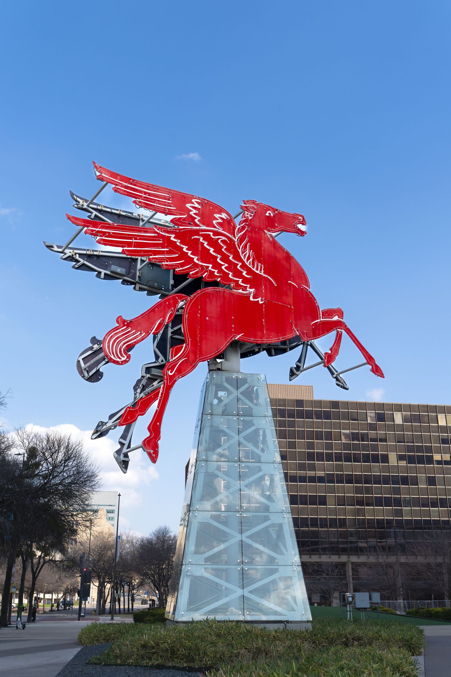 Iconic red Mobil Pegasus sign mounted on tall white pedestal in downtown Dallas.