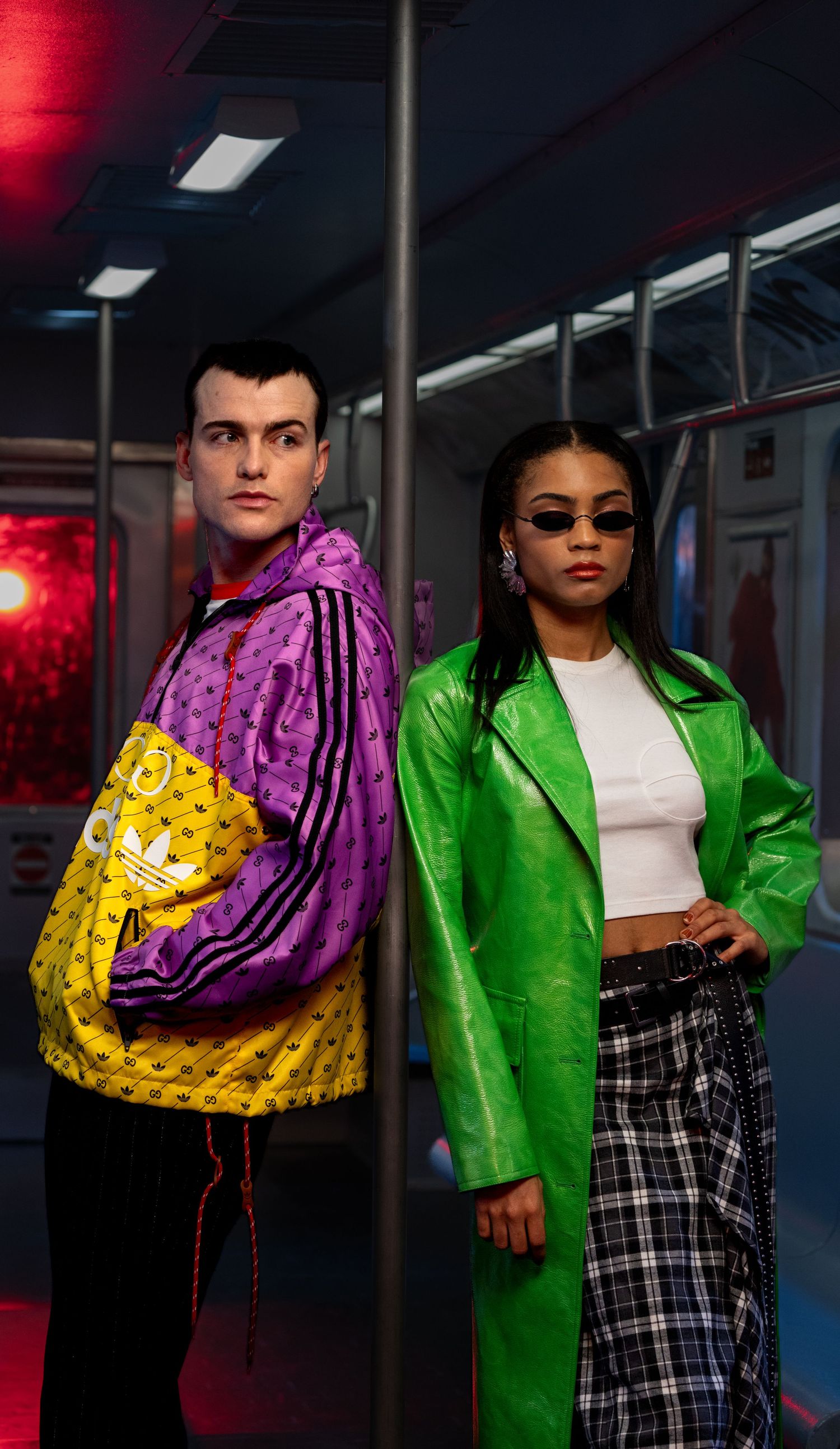 Models posing in vibrant green jackets and streetwear against dark backdrop with red lighting.