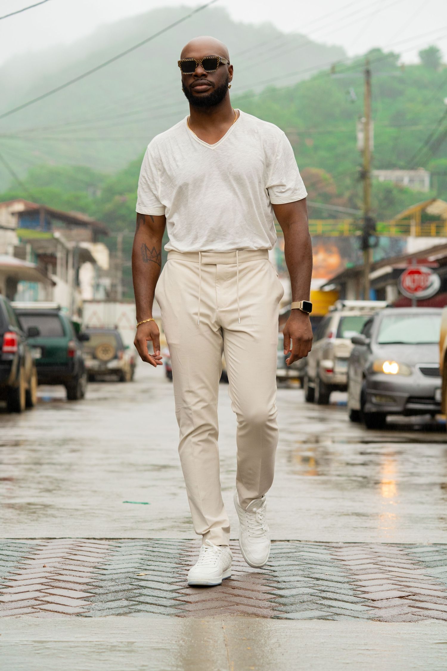 Stylish casual outfit worn on a rainy street with mountains in the background.