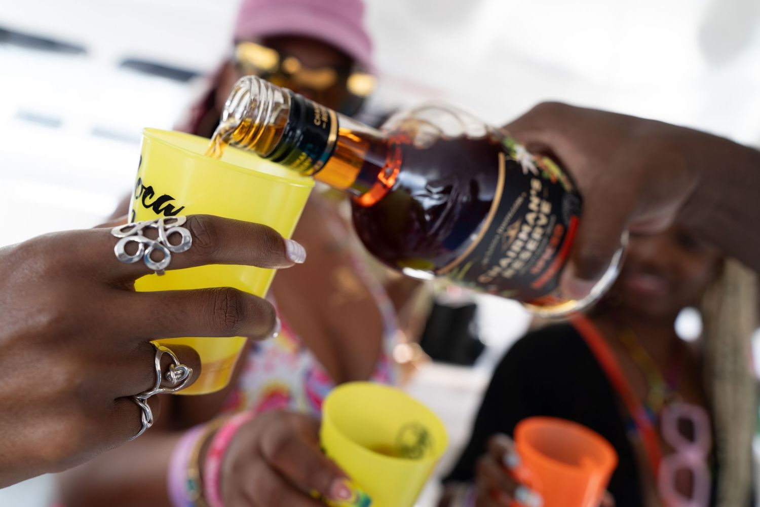 Close-up of hands pouring drinks on a boat deck.