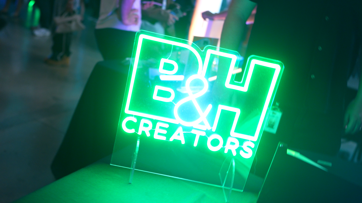 Vibrant green neon signs illuminate a dark nighttime scene with glowing text and symbols.