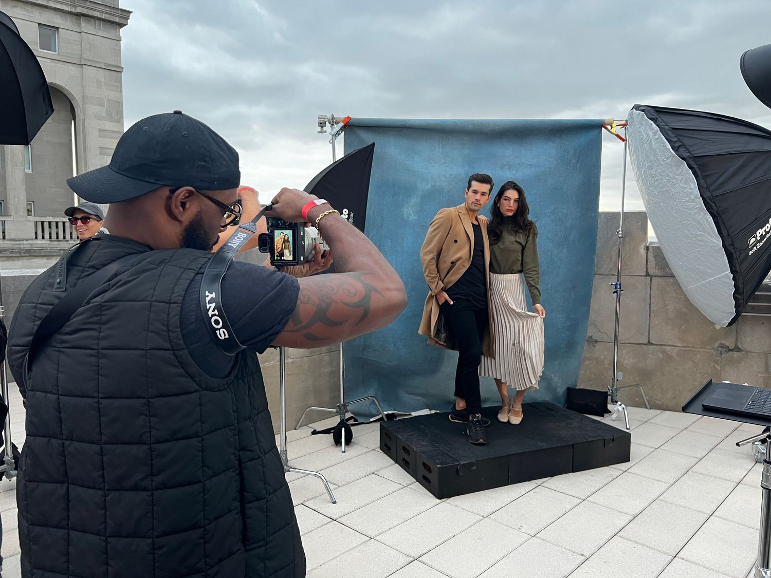 Behind the scenes photo shoot setup with lighting equipment and camera gear on a rooftop location.