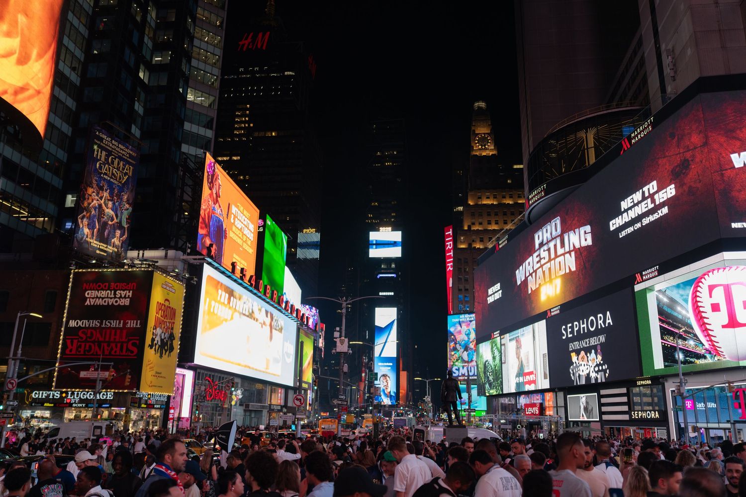 Panoramic view of Times Square's bright LED billboards and advertisements at night.