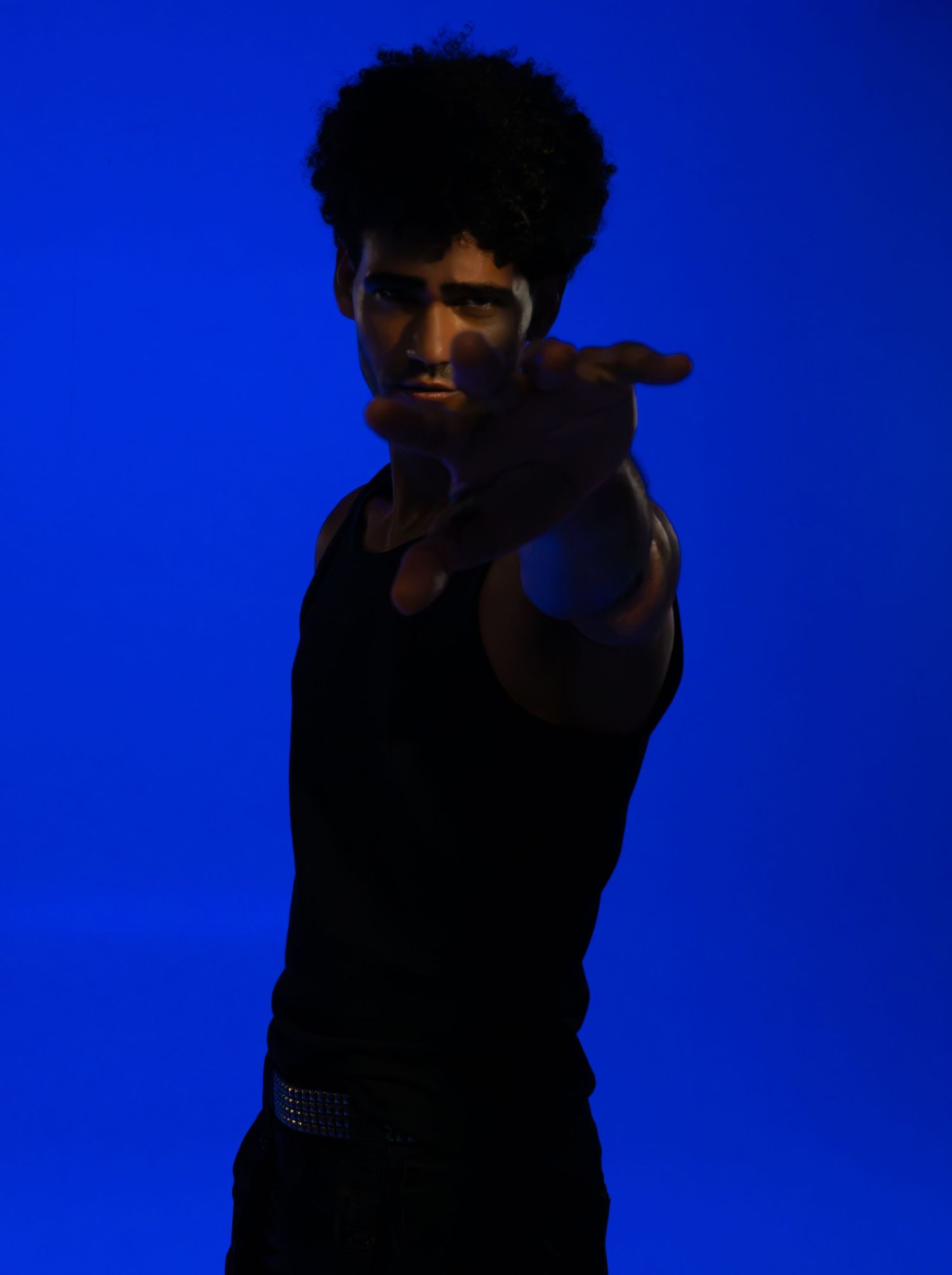 Dramatic silhouette poses against vibrant blue background.