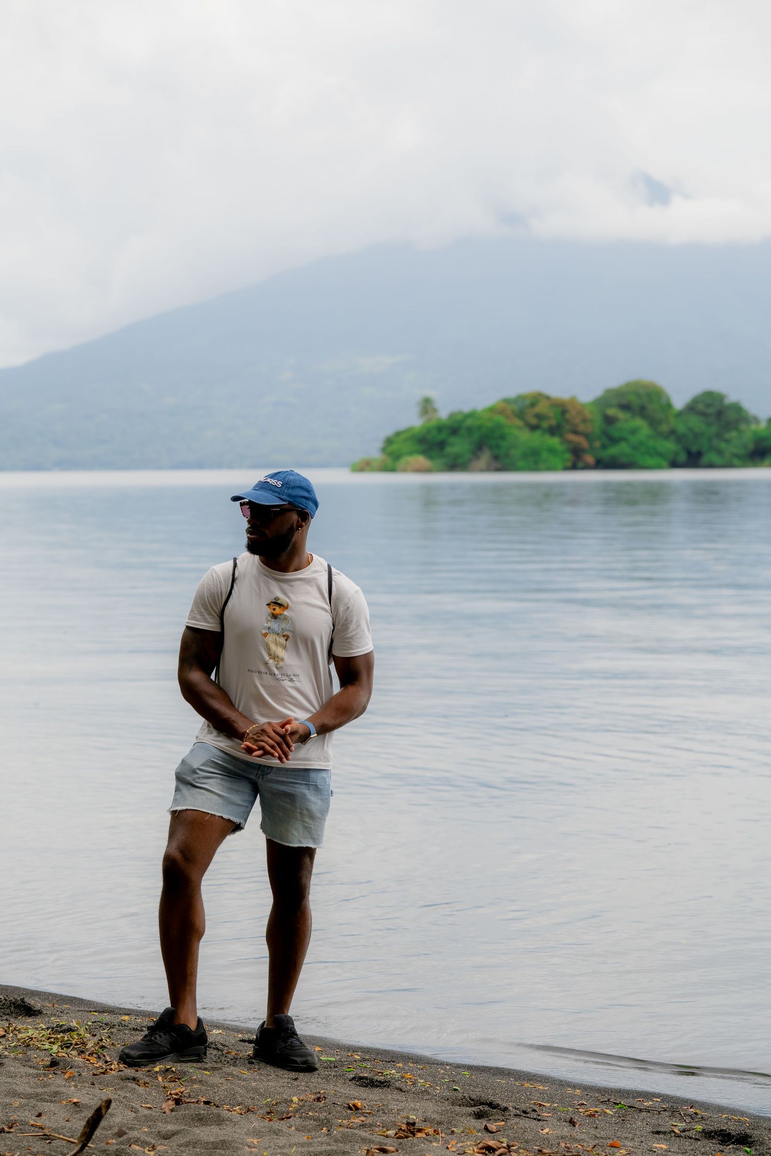 Serene lakeside scene with a mountain backdrop and person enjoying the peaceful view.