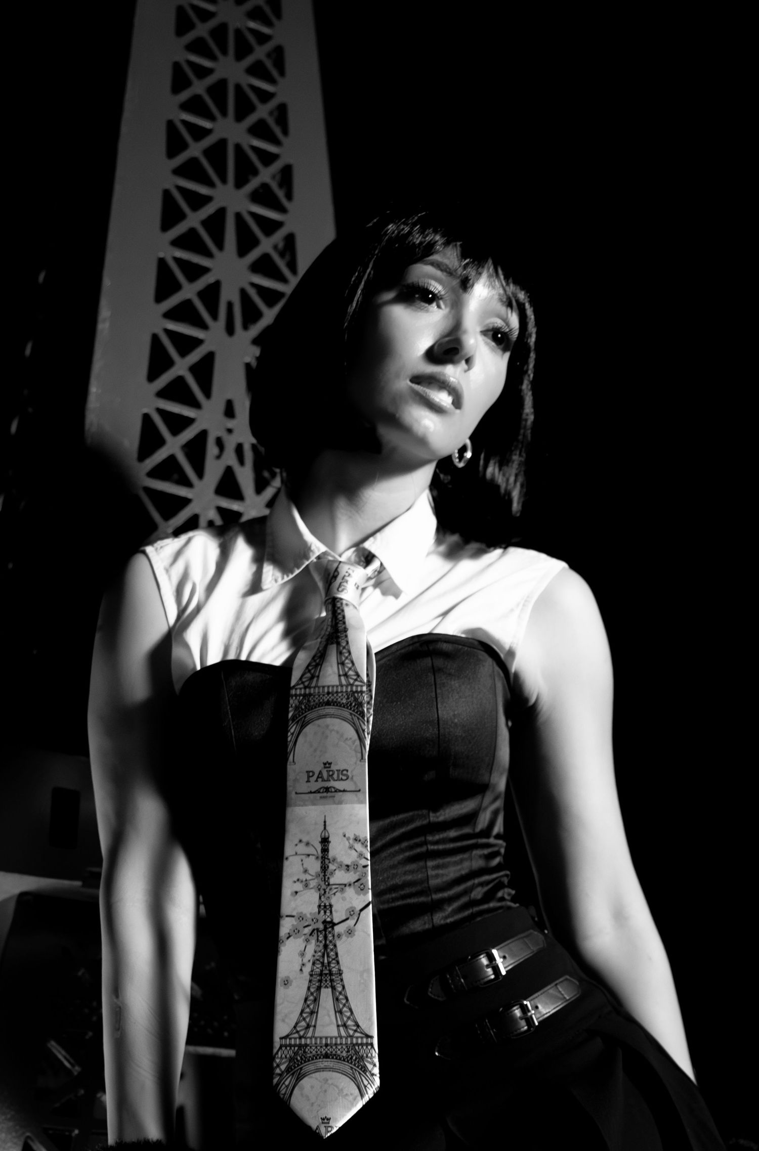 Black and white fashion photo featuring Eiffel Tower necktie and dramatic lighting.