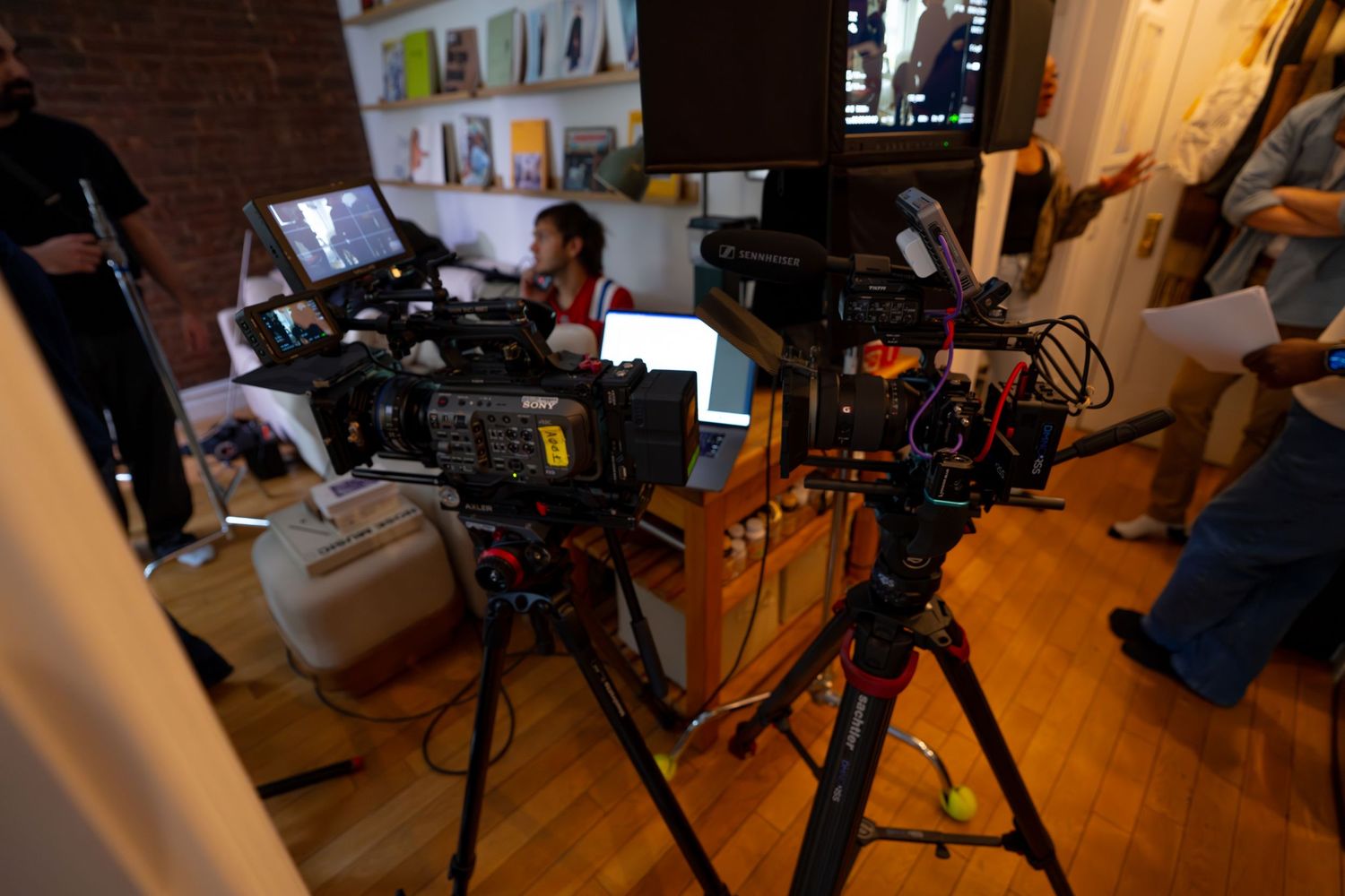 Professional camera equipment and telescopes set up in a dimly lit room for astrophotography.
