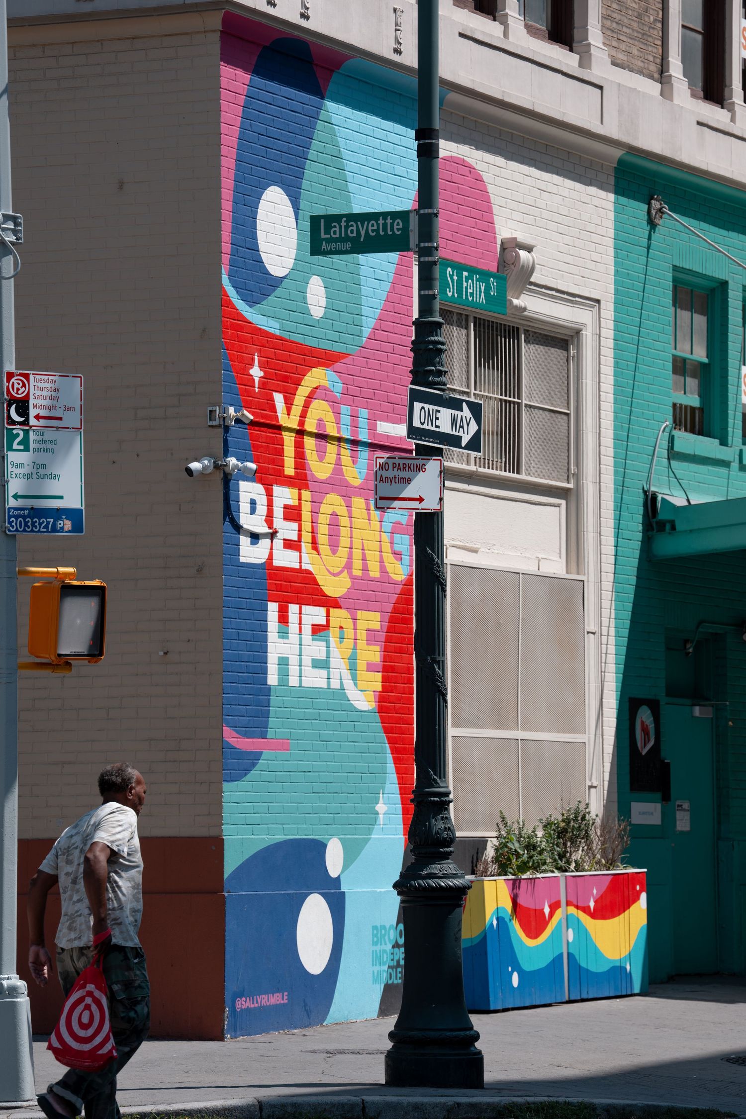 Colorful abstract mural painting on building wall along urban street corner.