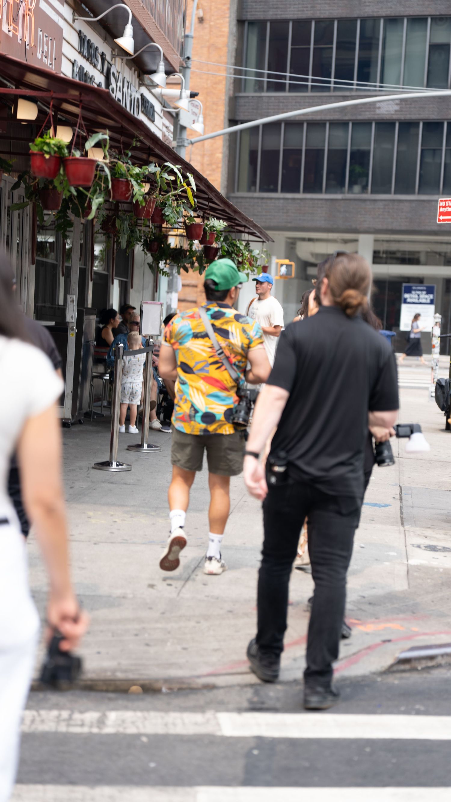 People walking on an urban sidewalk near brick buildings.