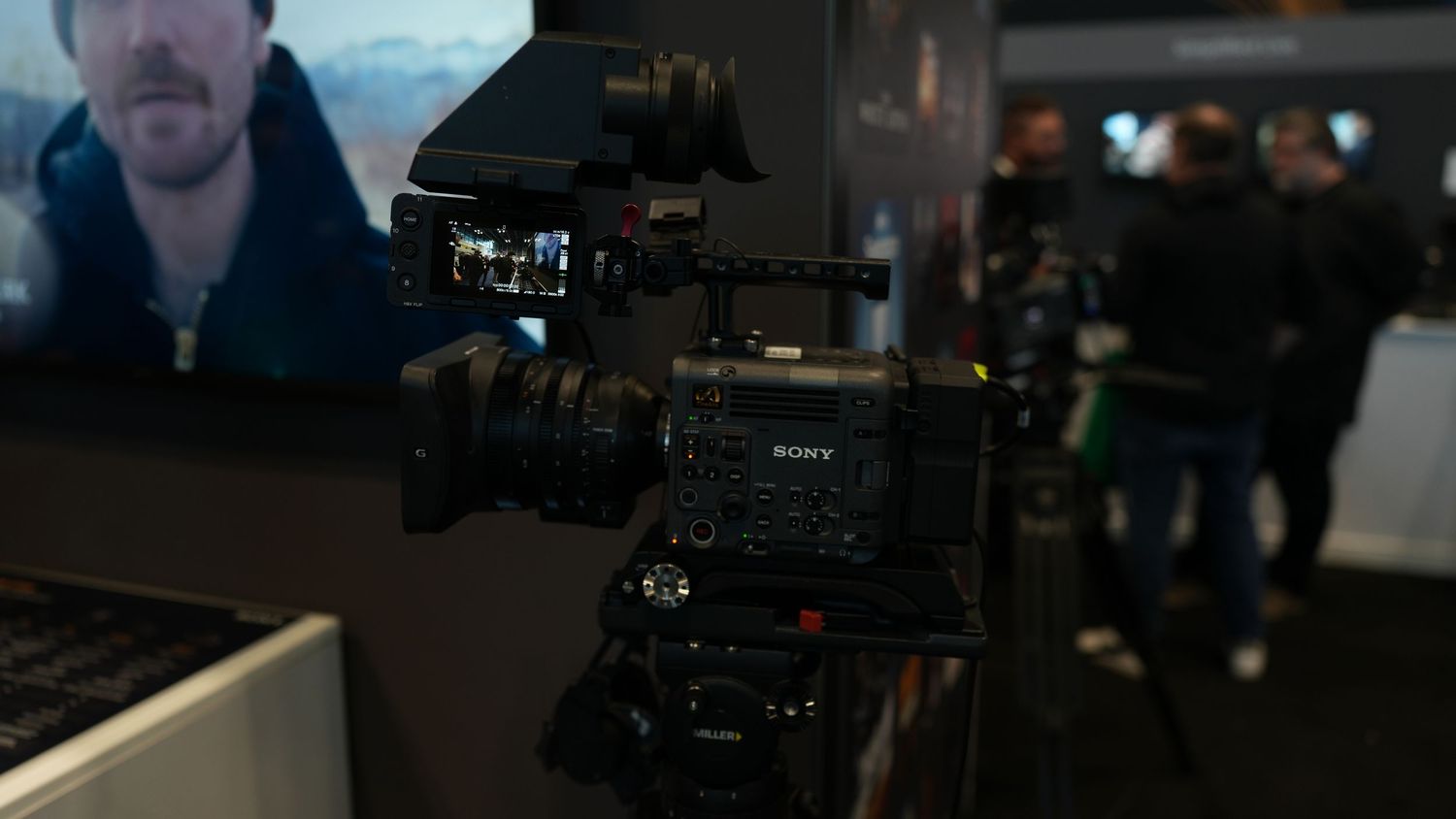 Professional camera equipment setup with multiple monitors and video production gear in a dark studio environment.