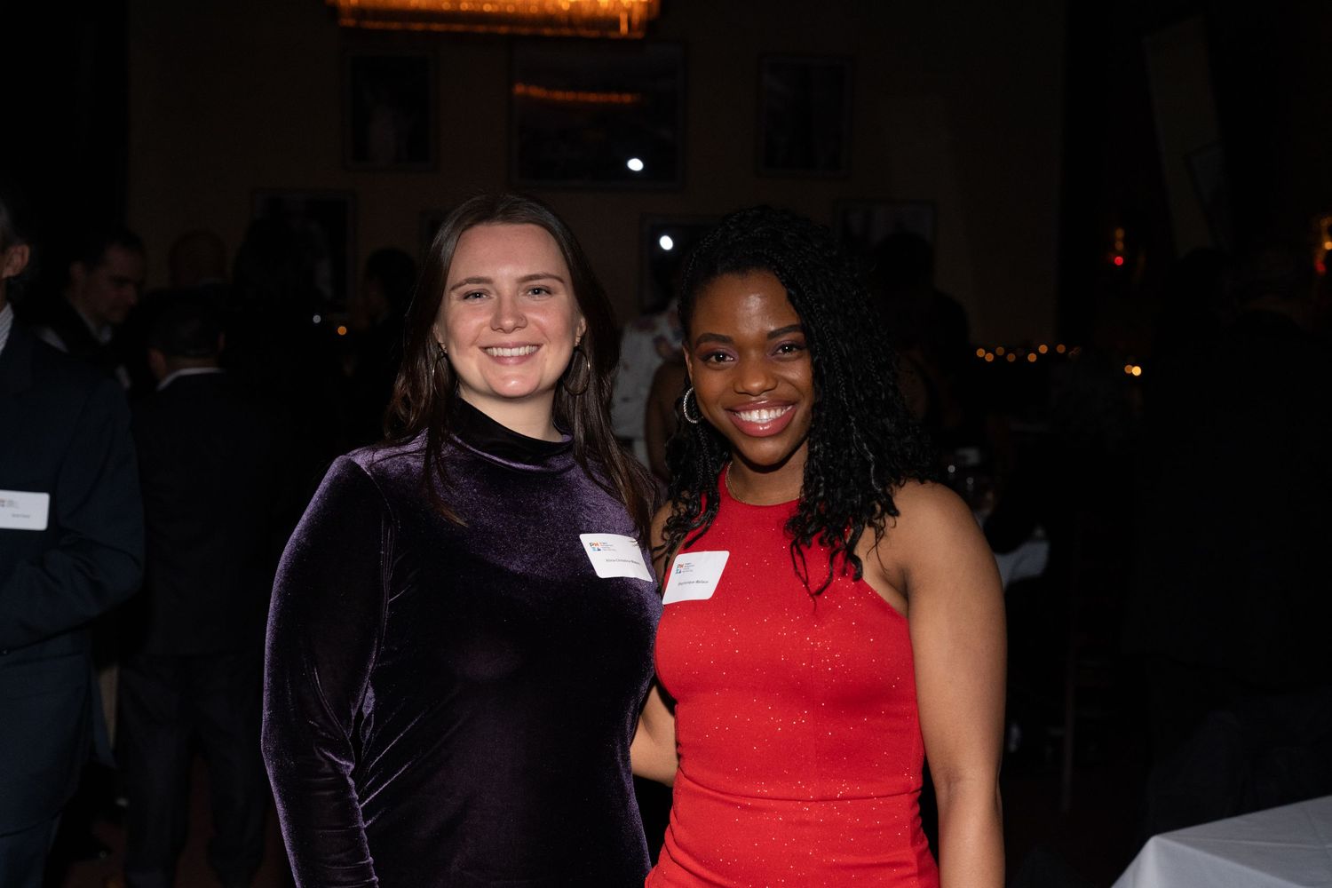 A group of people socialize and smile together at an evening networking event.
