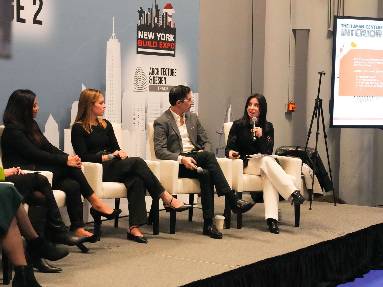 Panel discussion at New York Build Expo featuring four professionals seated on stage at an architecture and design conference.