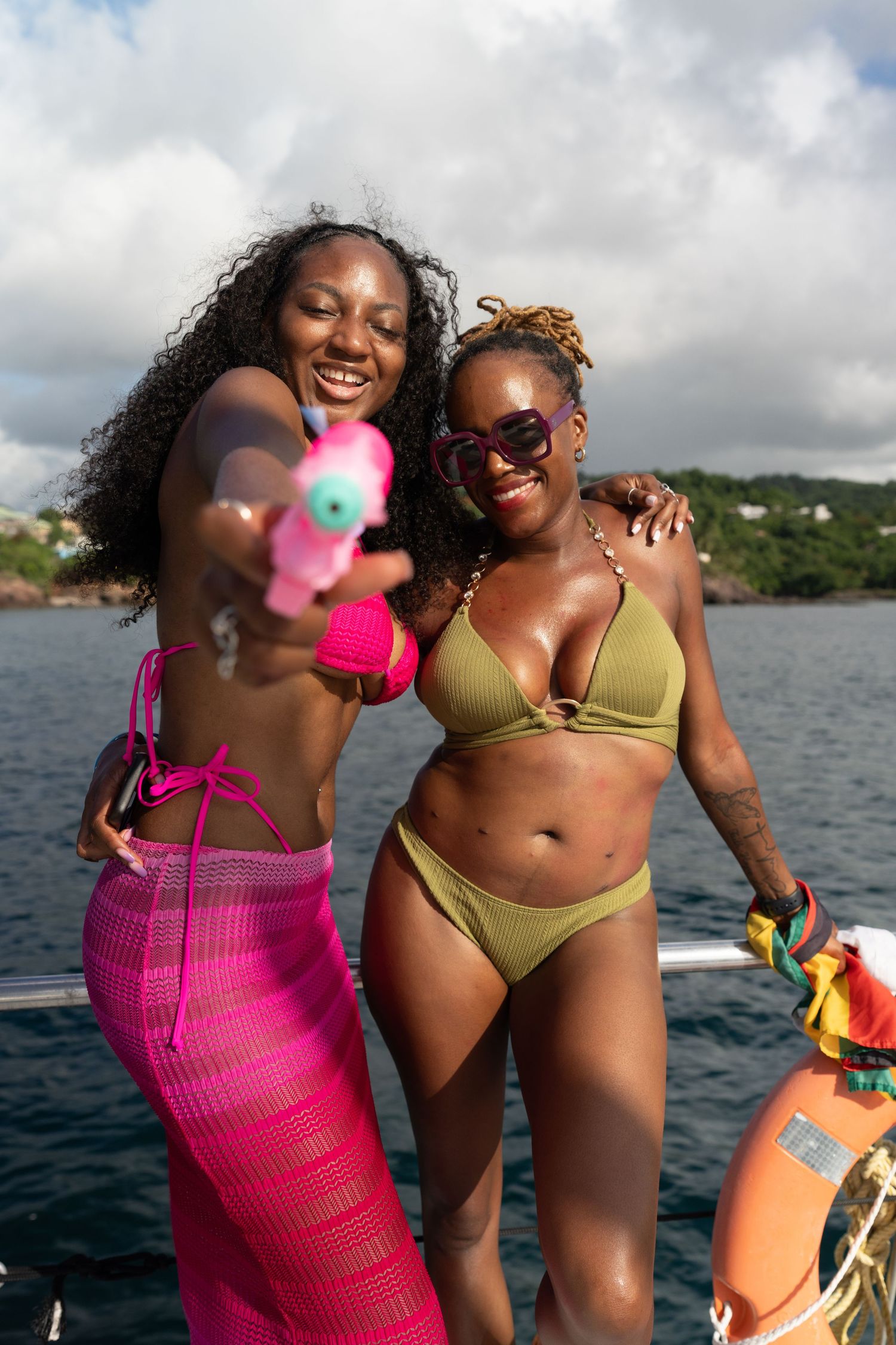 Friends in swimwear share joyful moment on boat deck.