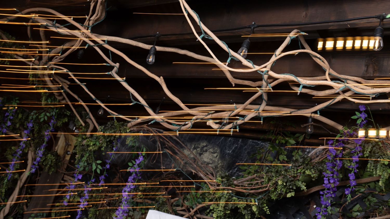 Rustic restaurant interior with exposed brick walls and decorative branches.